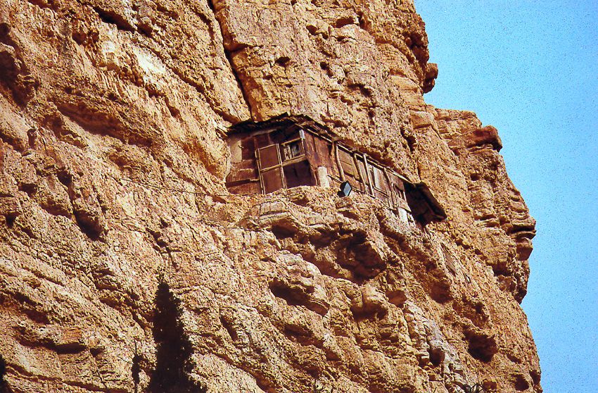 Monastic cells are tucked into crevices along the cliff; some seem almost inaccessible.