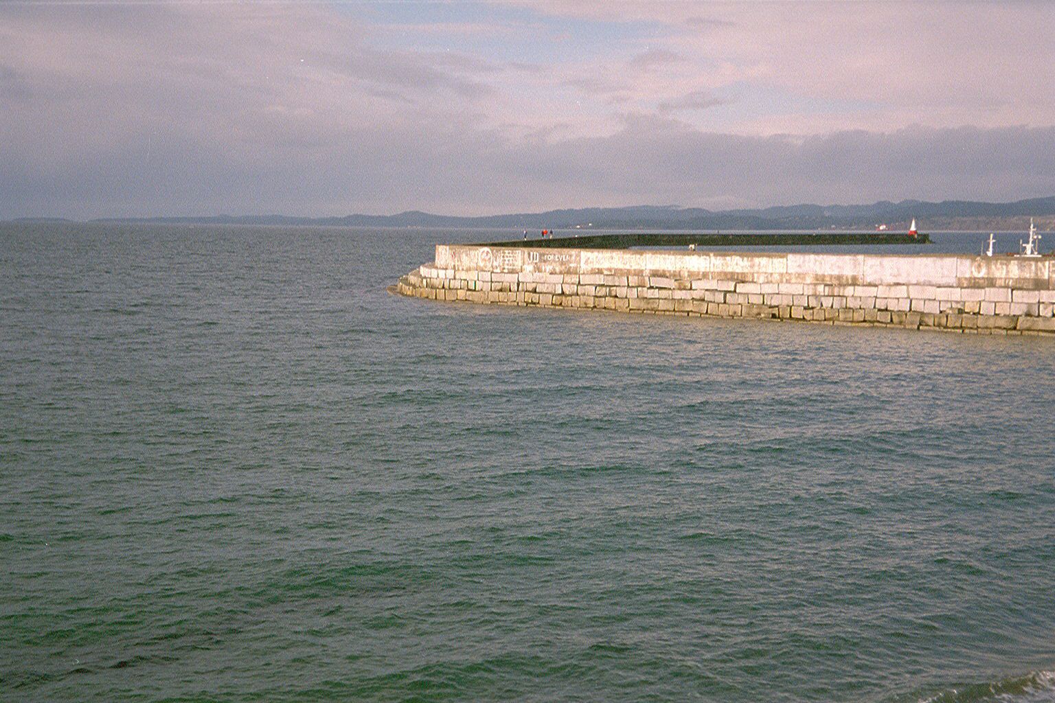 An unnamed breakwater calms the waters of Juan de Fuca Strait at the entrance to Victoria's harbor. That's a pyramidal lighthouse at the end