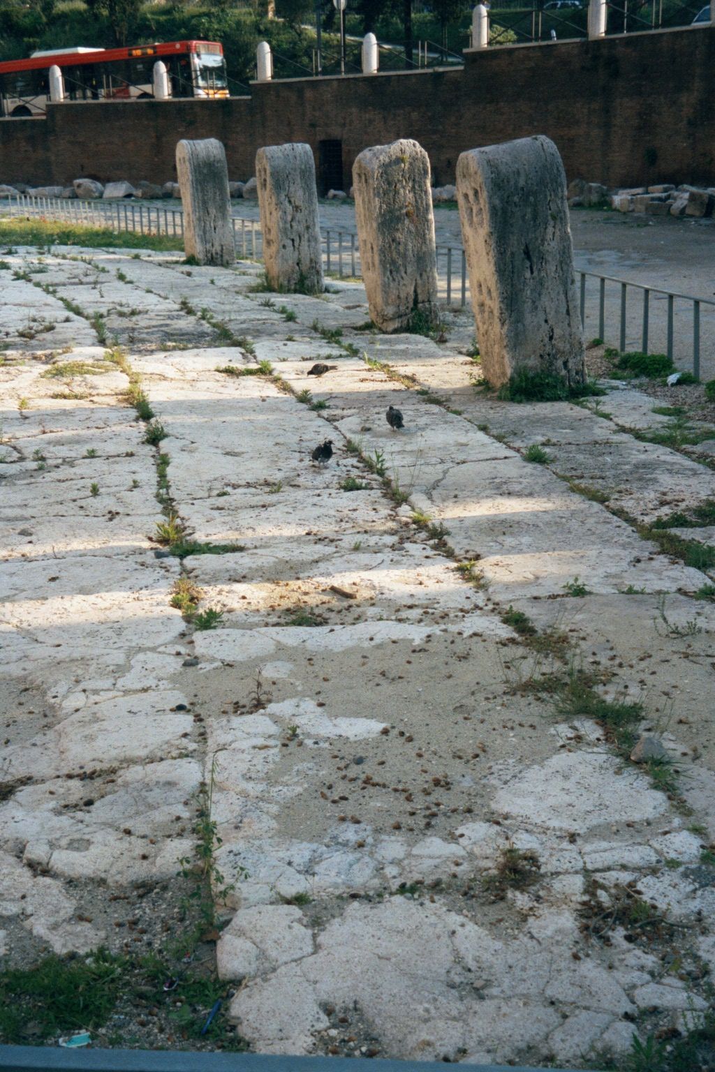 Most of the surrounding ground is modern, but on the east side there's a patch of ancient travertine flagstones and a line of boundary stone
