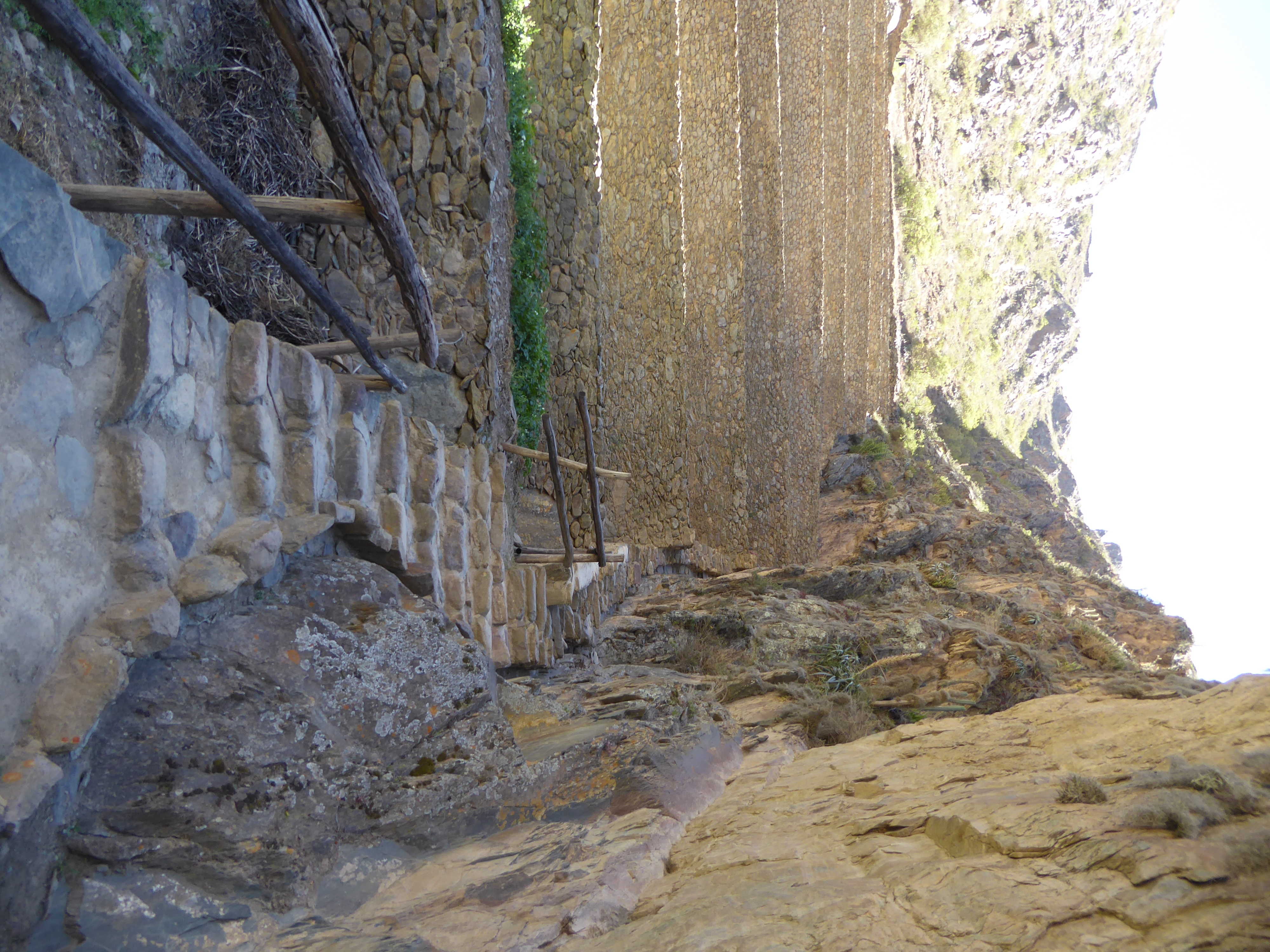 A supply ditch hugs the cliff, and conduits under the path bring water to the terraces, whose walls are permeable by design.