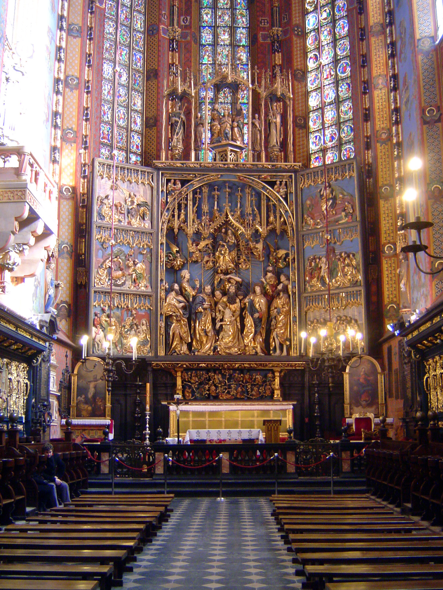 The Virgin appears three times on the altar: below at her death; above at the assumption; and up top at her coronation as queen of heaven. T