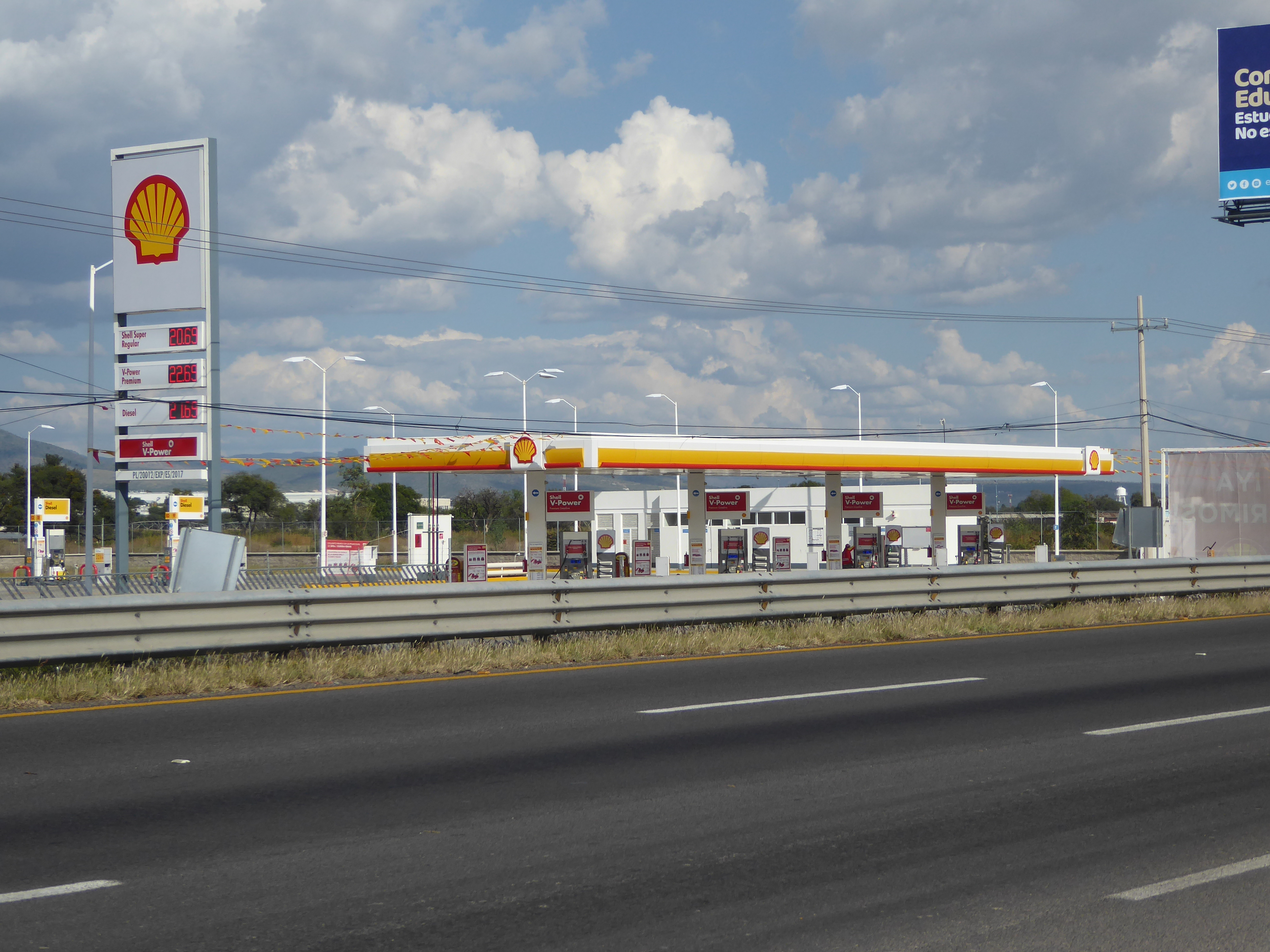 Stores like these imply shoppers with cars, which at least partly explains highways like this and gas stations to match.

Anyone who grew up
