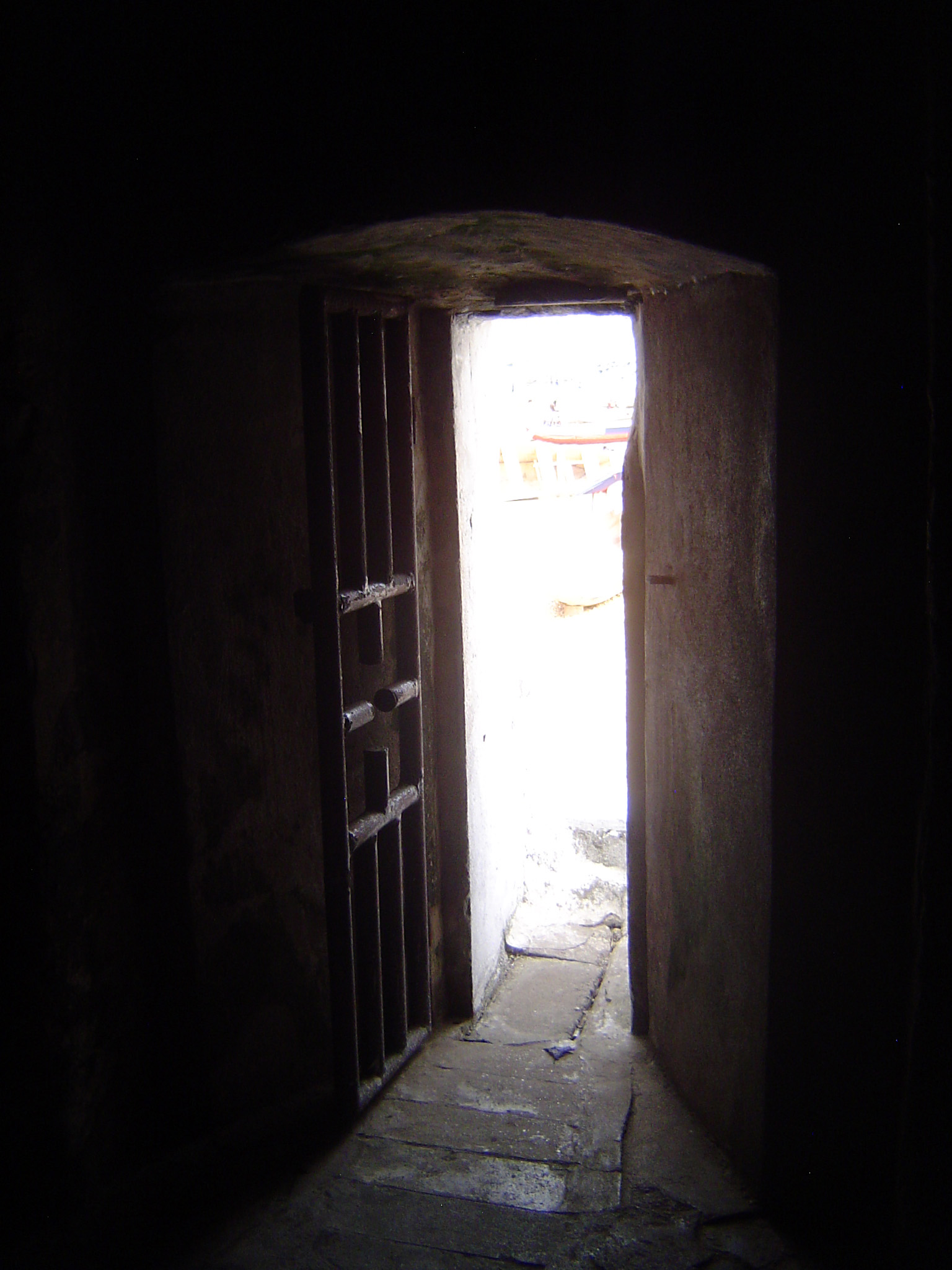 A narrow door leads from a dungeon to a water-side exit. There might as well be a sign saying "one-way."