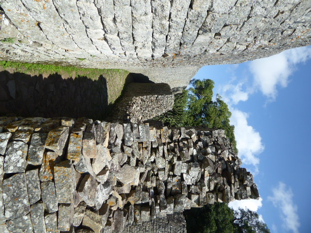 We're walking down the parallel passage; part of the inside wall is broken, revealing the internal structure of the wall, jumbled inside but