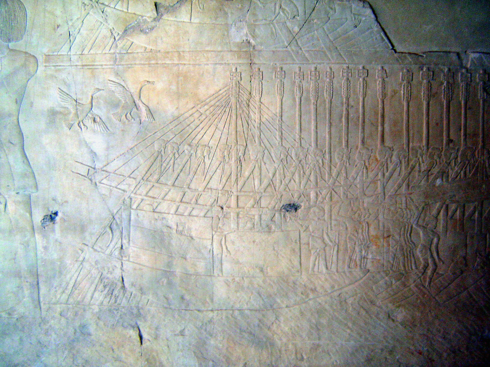 A grain-transport ship unloads at Thebes. The handles of the oars are carved with images of the king.