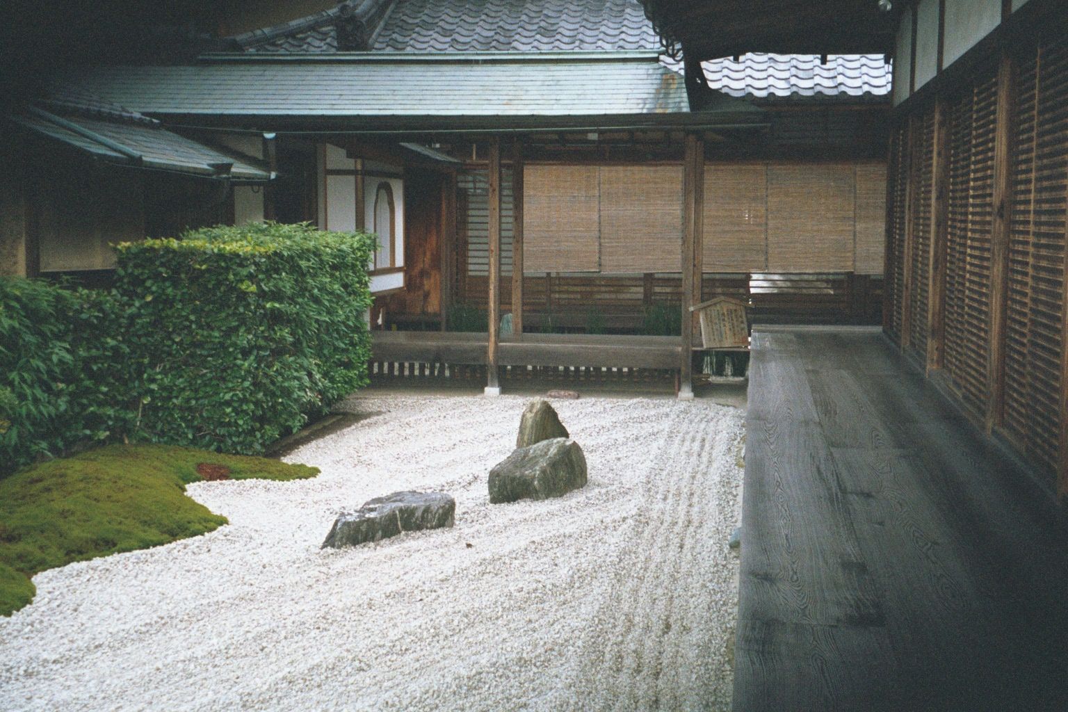 Inside a dry garden karesansui, literally "lacking mountain or water", with artfully chosen stones, meticulously raked gravel, and bordering