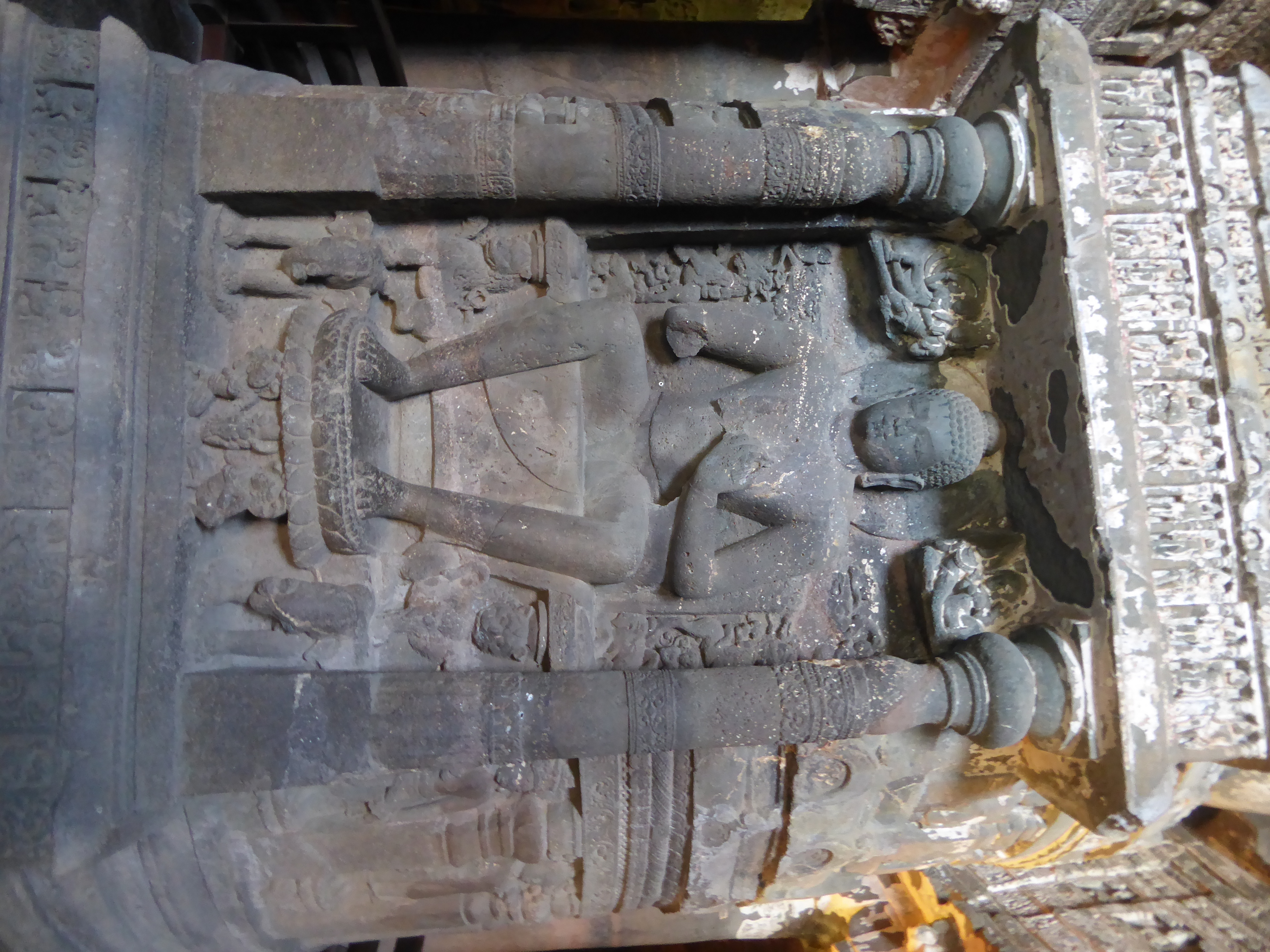 The figures that usually flank the Buddha have, for lack of space, been moved onto the drum.