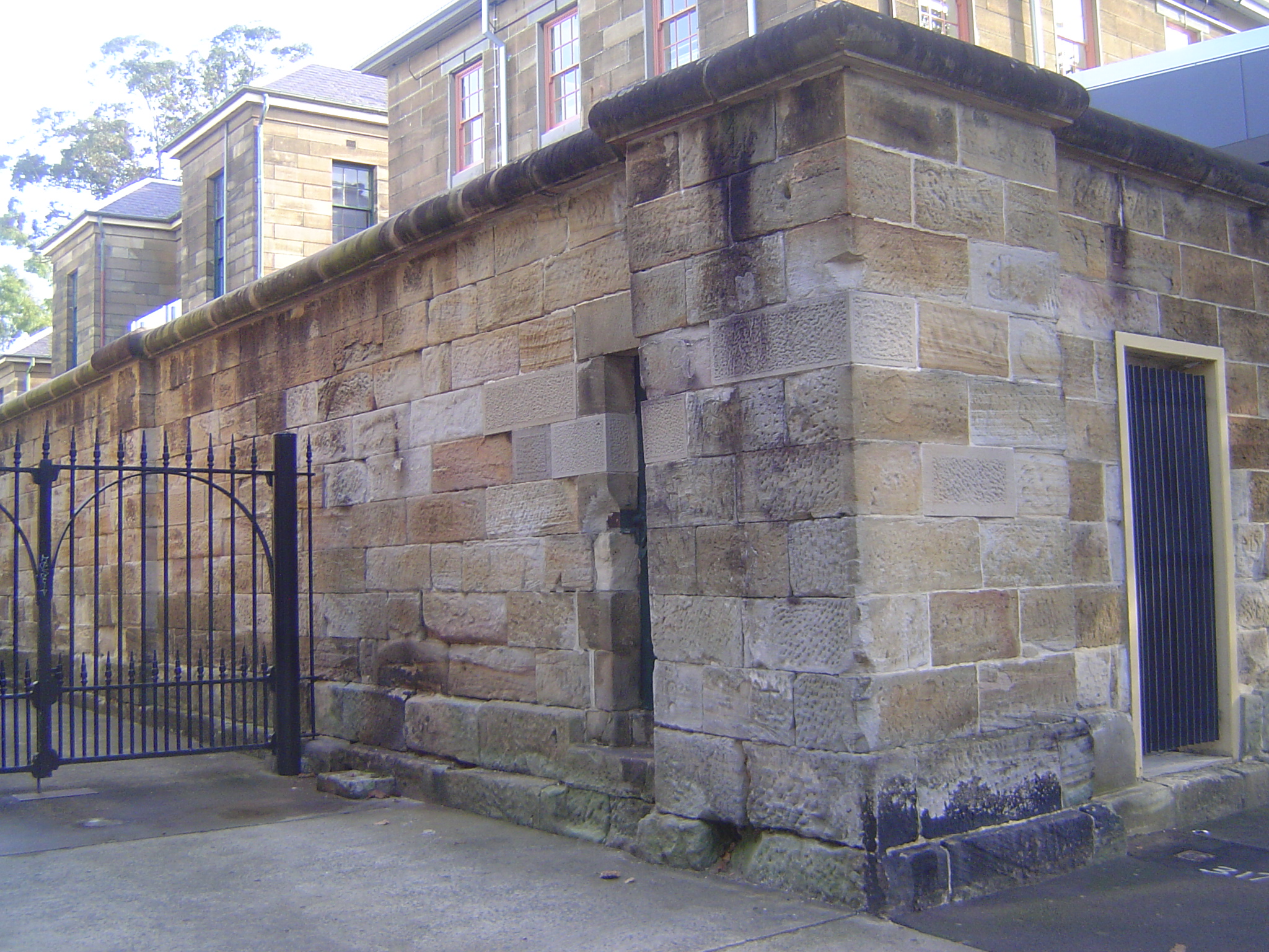 Out back, there's a fine wall of Hawkesbury sandstone. What's behind it? The answer is the fine, Panopticon-style Darlinghurst Gaol, designe
