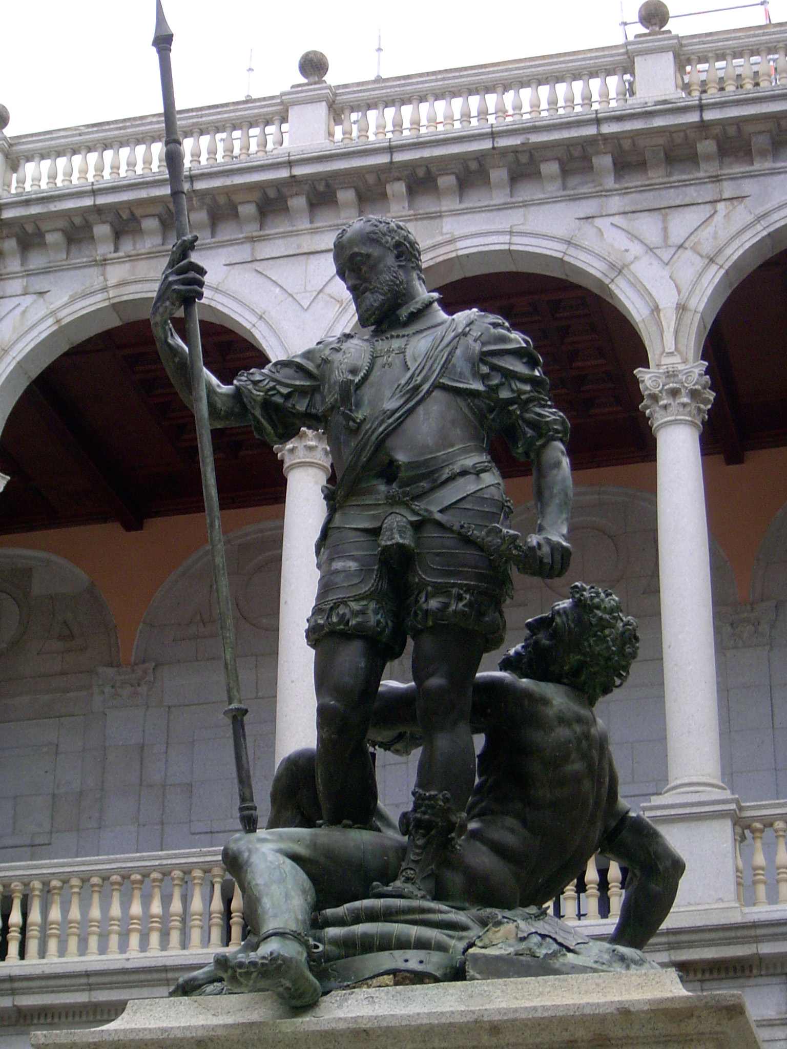 Despite the archaic dress, the figure is Alfonso XIII, king of Spain from 1886 until 1941. Here he stands victorious over a chained African