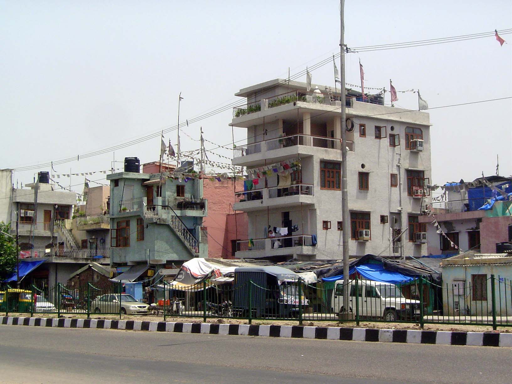 This is Delhi's Outer Ring Road. We'll get across on a pedestrian overpass, but notice first those flags up top.