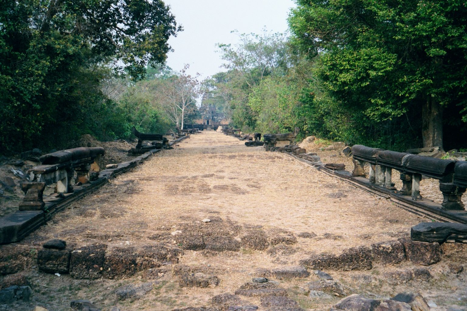 We've moved east about three miles and are looking west on the causeway that leads to Banteay Samre. You recognize the naga balustrade. Ahea