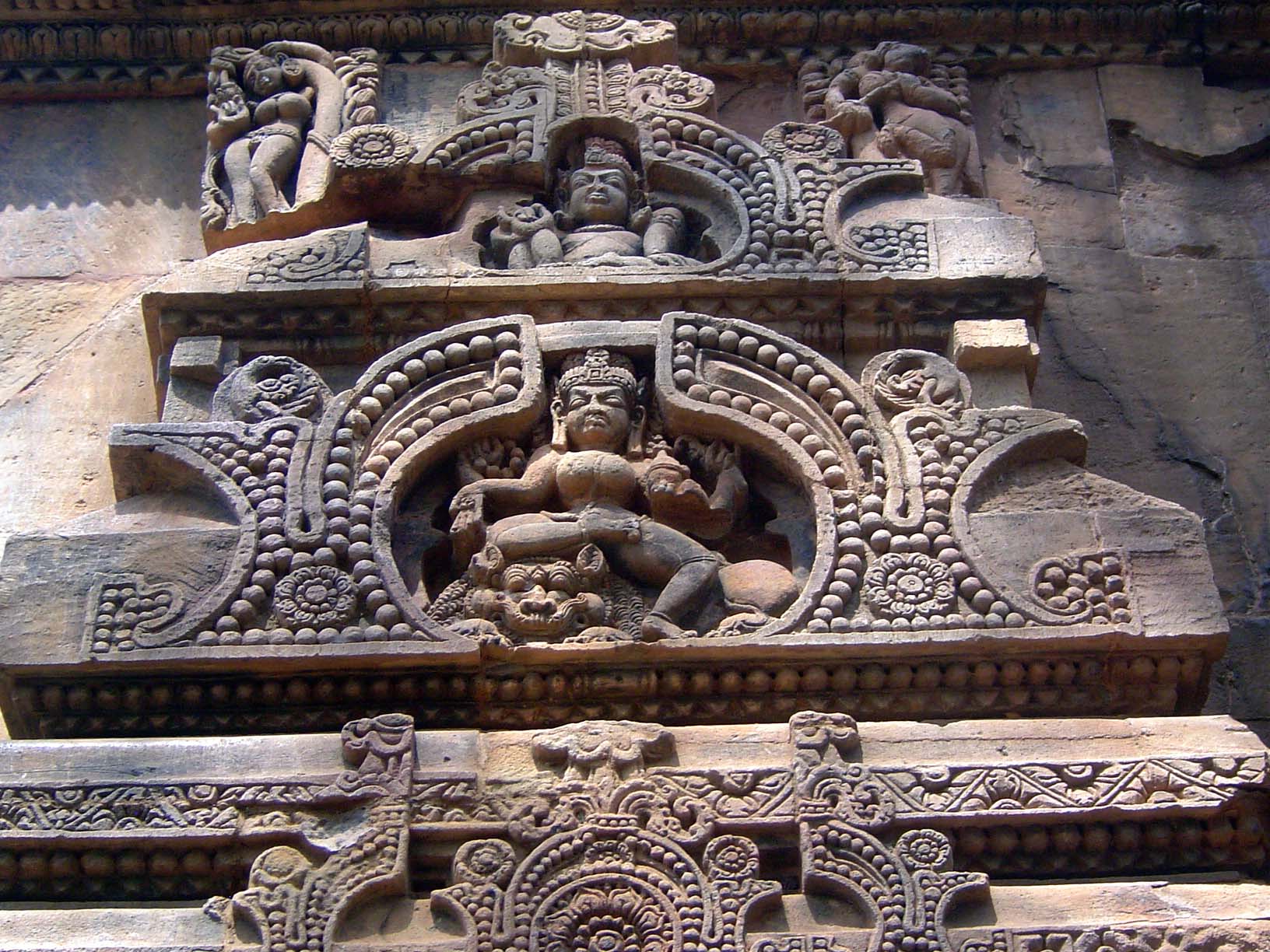 Similarly sheltered by an arch, Shiva dances on another side of the sanctuary over the demon Ravana.