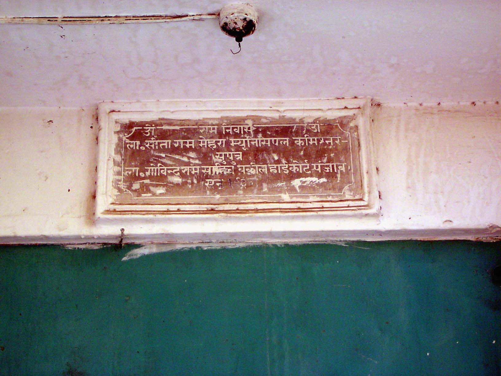 This plaque, affixed to the wall of the same building, reads, in Hindi, "Commissioner Sita Ram Mehra, son of Sir Govind Ram, Advocate, High