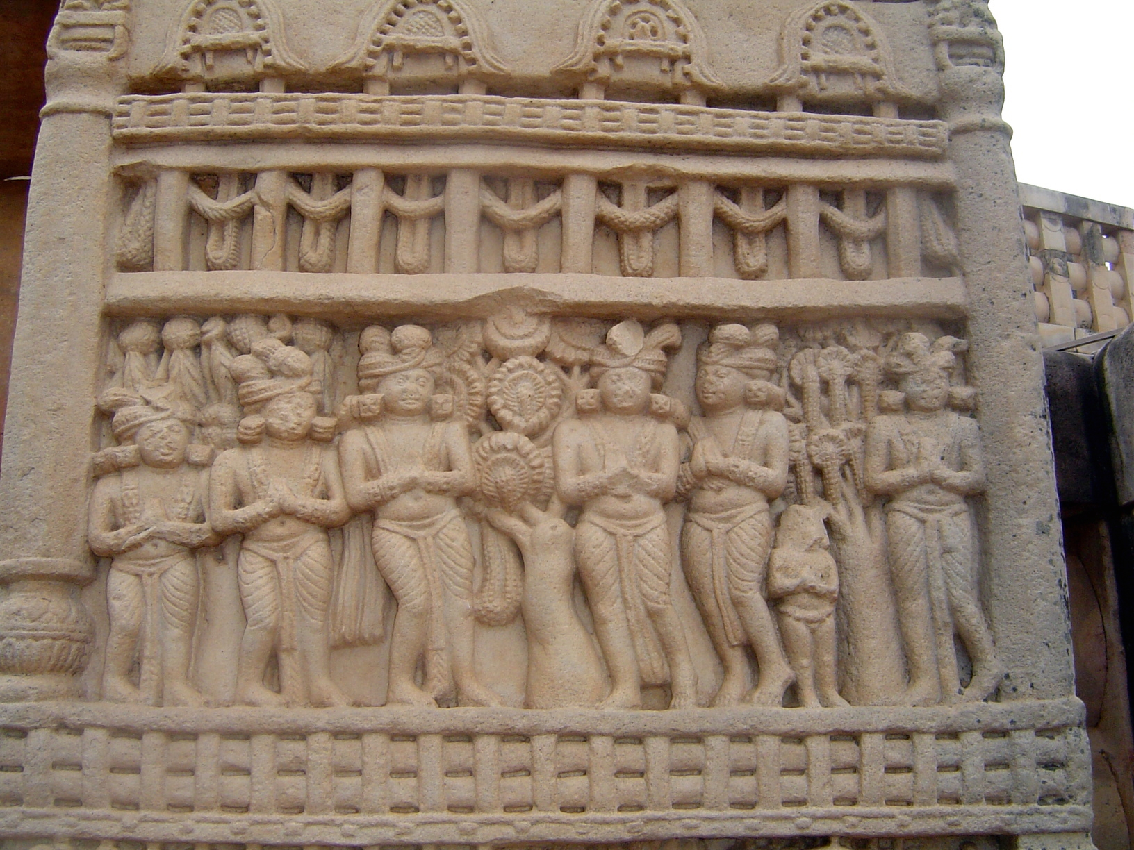 Here's the base of the front side of the east pillar of the north gate, showing the miracle of Sravasti. The skeptical court of Prasenajit w
