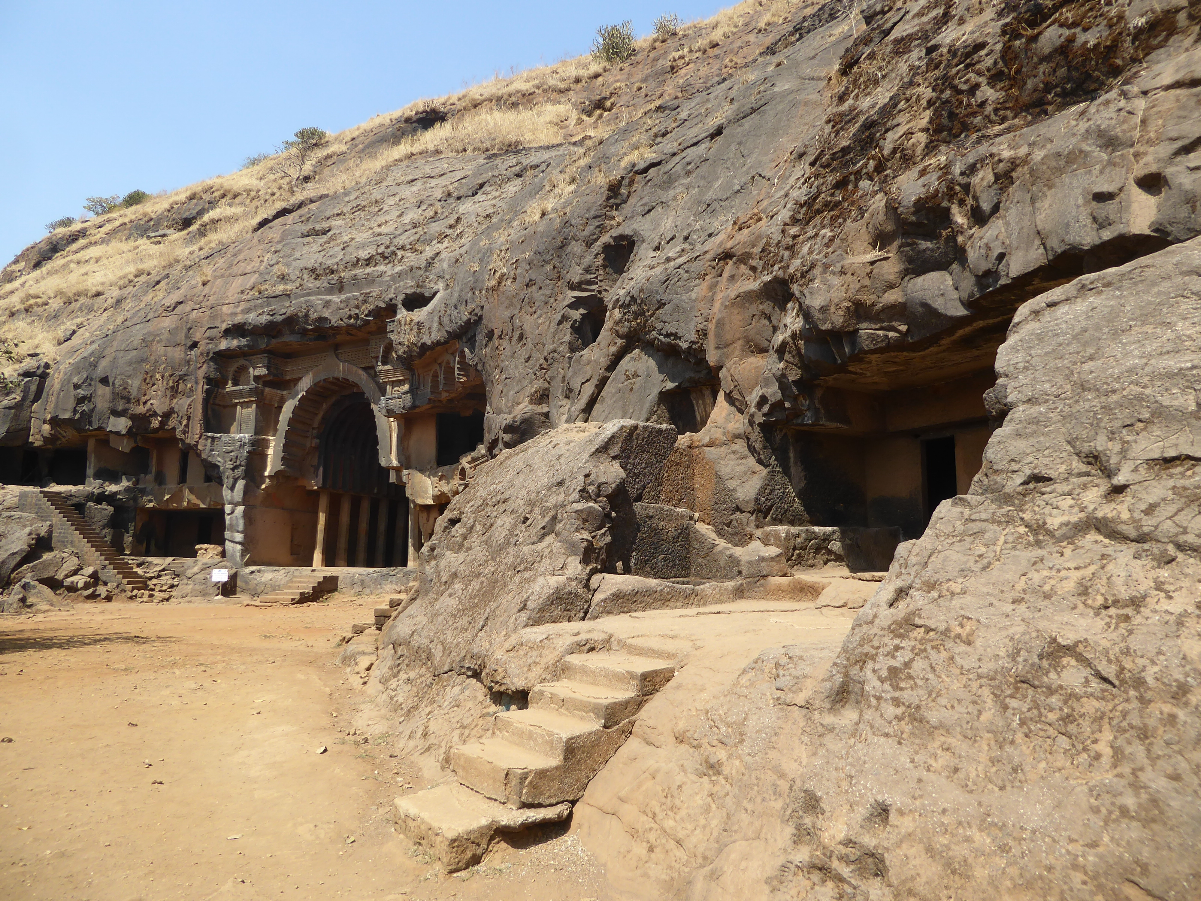 Bingo. The arch is the entrance to a chaitya or prayer hall. The other caves are mostly monasteries, basically living quarters. The flights