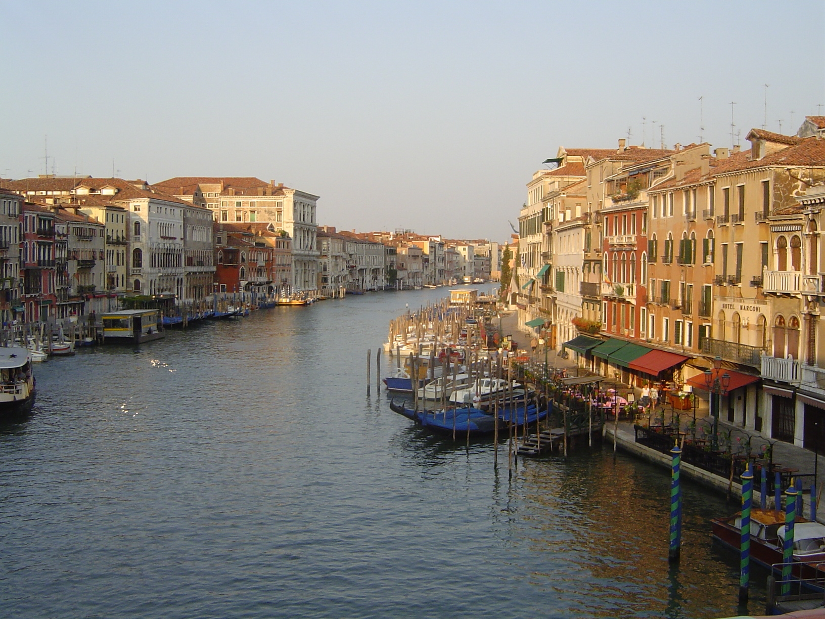 From either side of the bridge, the canal gently curves away. This view looks south. On the left, after a succession of smaller buildings a