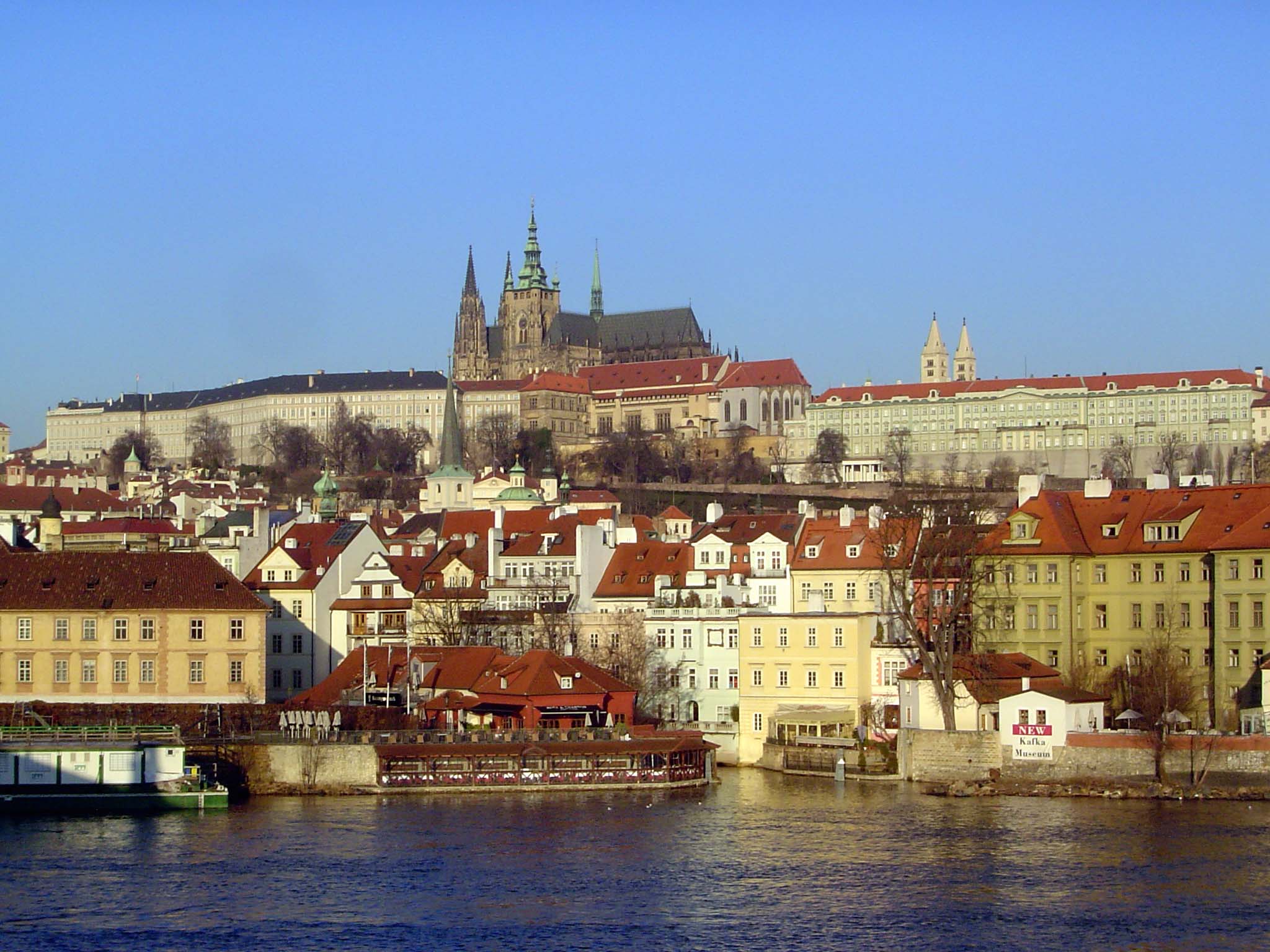 Across the river, St. Vitus Cathedral, within Prague Castle, rises in the morning light.