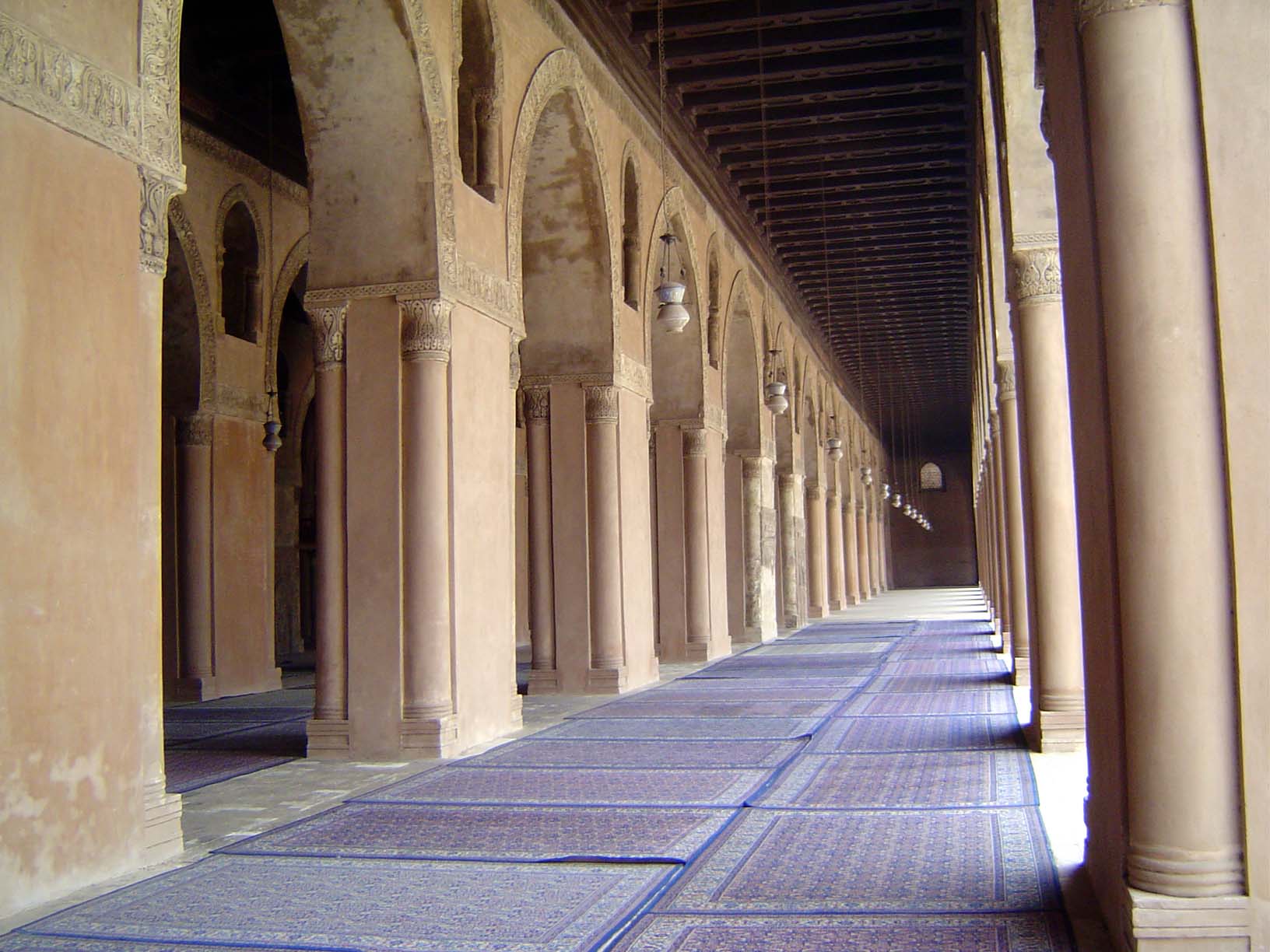 Arcades of brick piers run along the qibla side.
