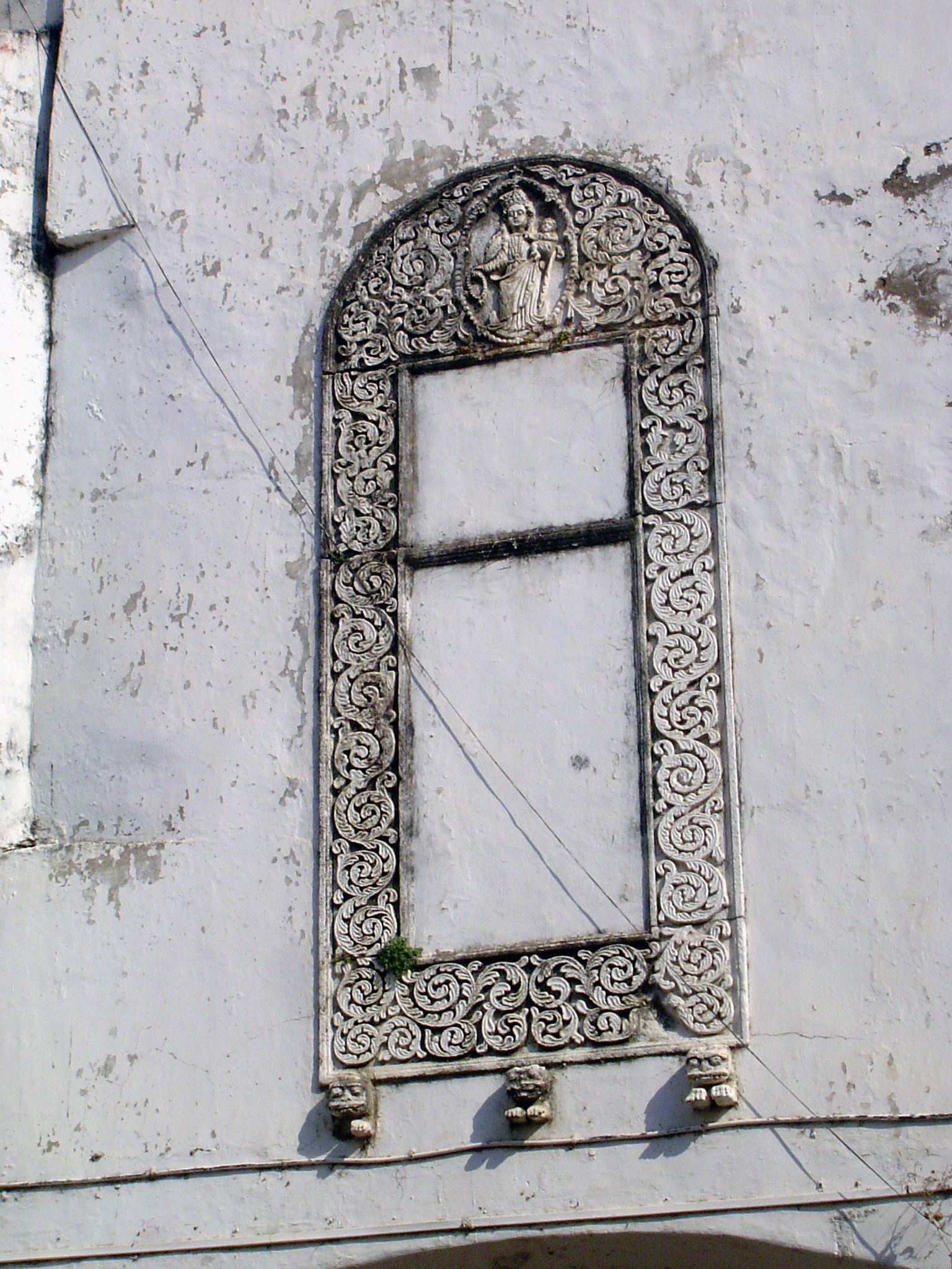 Another virgin and child in a floral frame supported by three lion brackets.