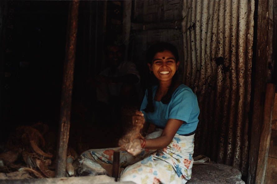 One source of local income: an Indian girl using a hammer to break coconuts—hundreds of coconuts, mountains of coconuts.