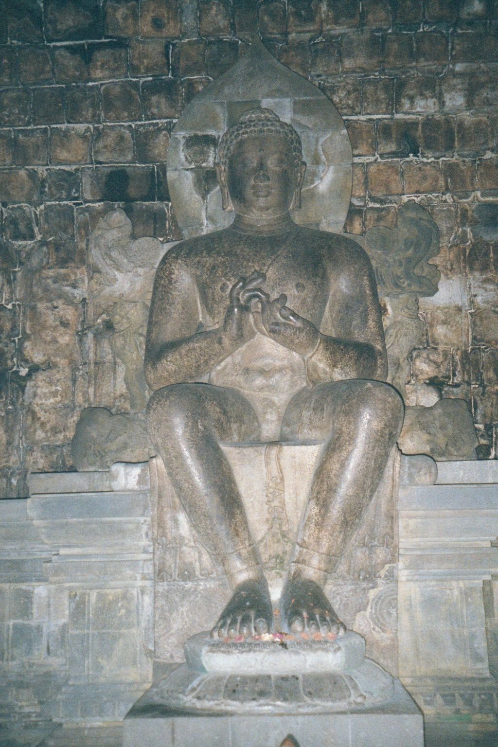 The Buddha, shown in a Western-style sitting position, which is unusual.