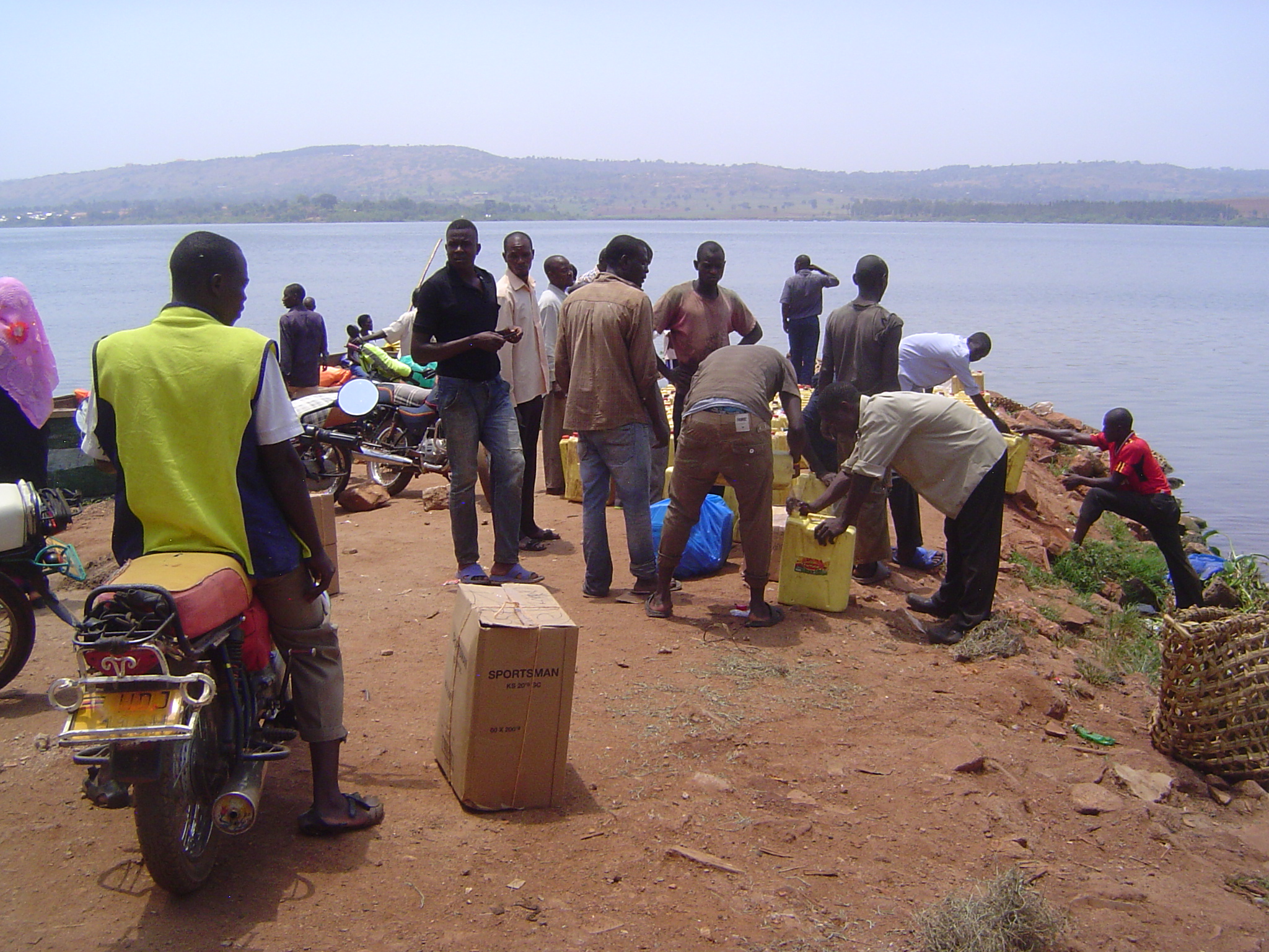 Men stand around with freight to be shipped. Wonder what the plastic jerrycans contain?