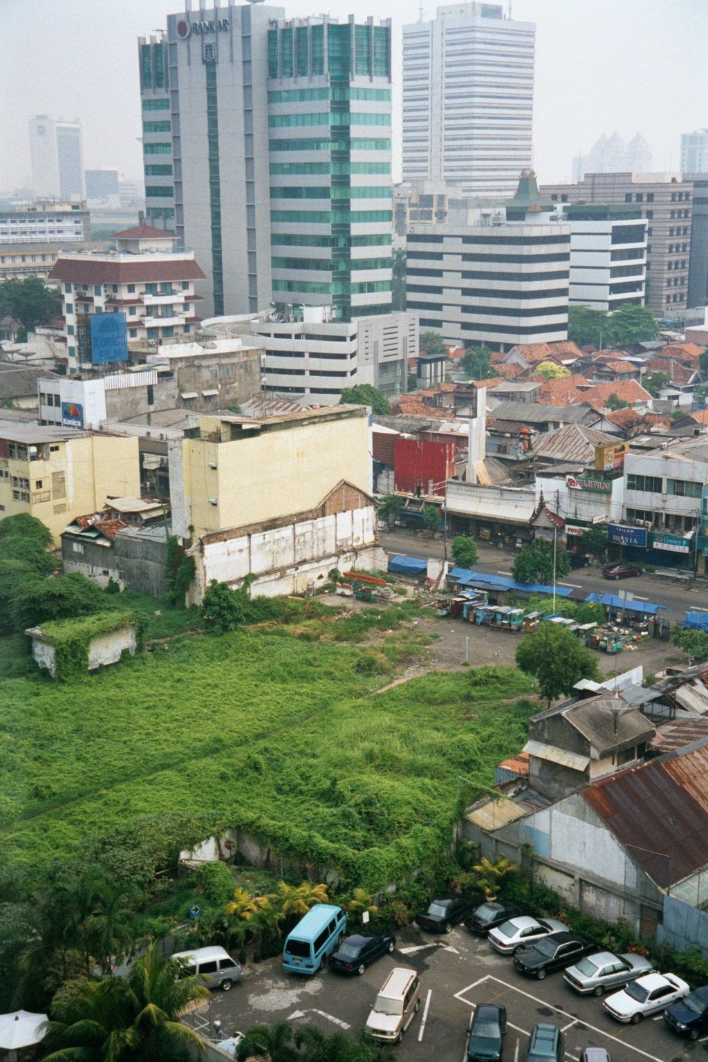 The view northeasterly has a chaotic mixture of vacant land, small buildings, and highrise towers.