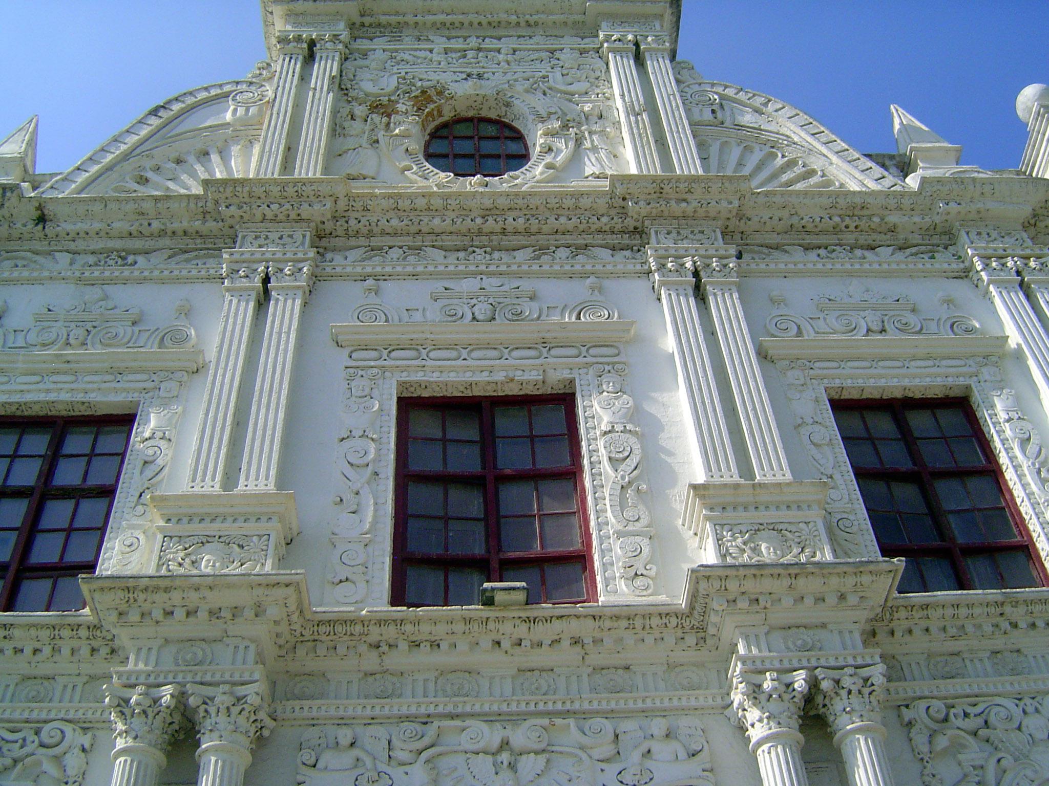 Faces are embedded in the plaster. How many? I count ten in the second and third tiers.