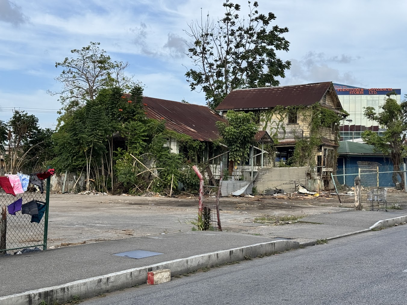 Here, on the Chaguanas Main Road, is the falling-apart office of what was the public-health officer.  Something new is coming, as glass-fron
