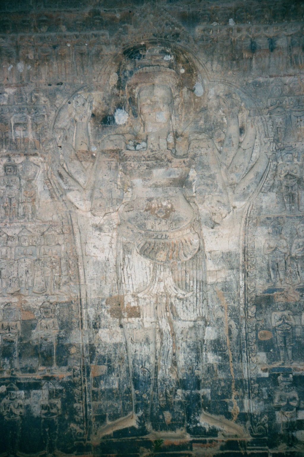 Vishnu with eight arms; attendants on either side.
