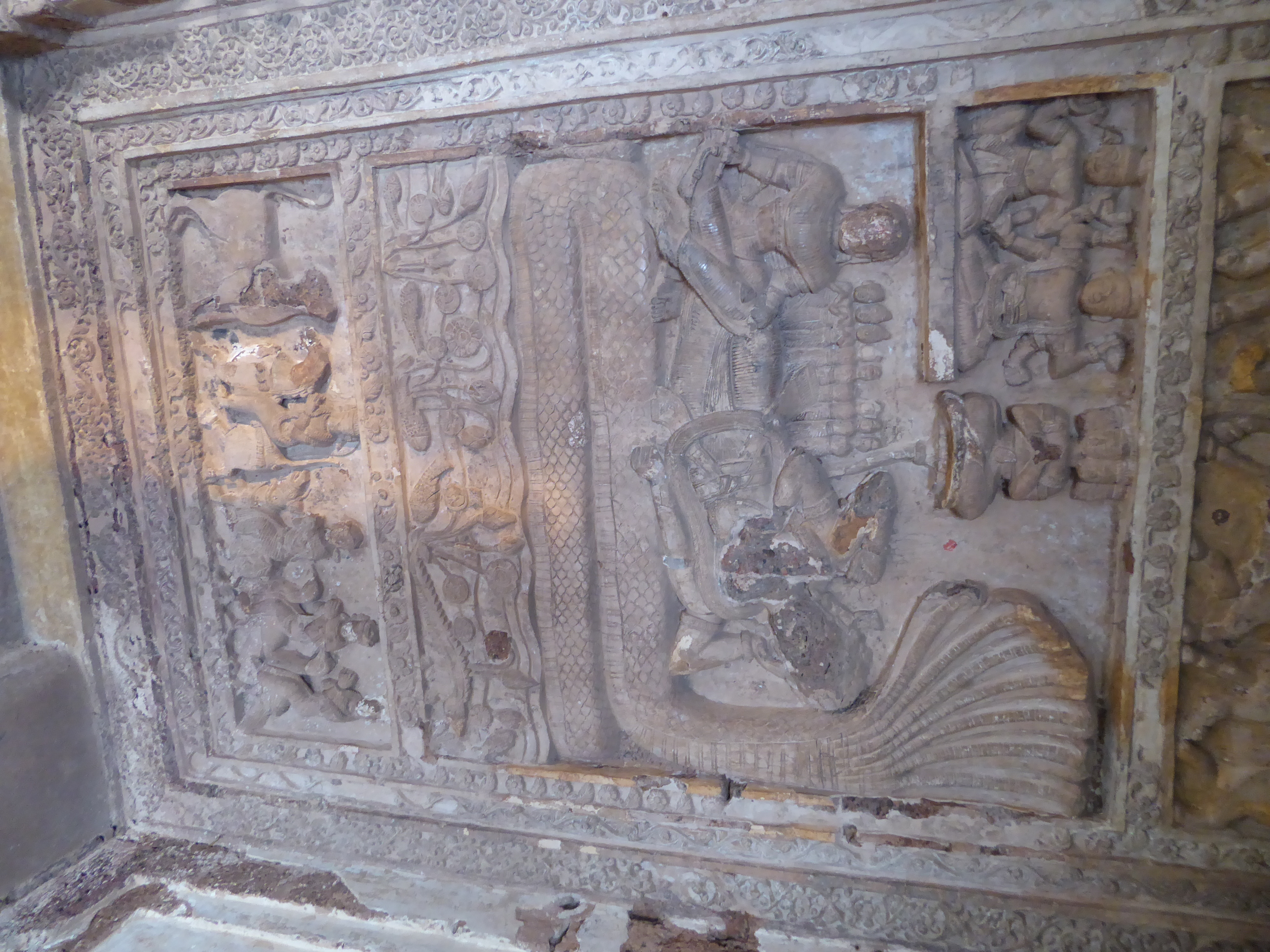 A sheltered panel shows Vishnu asleep on Sesha and dreaming the world's Creation.