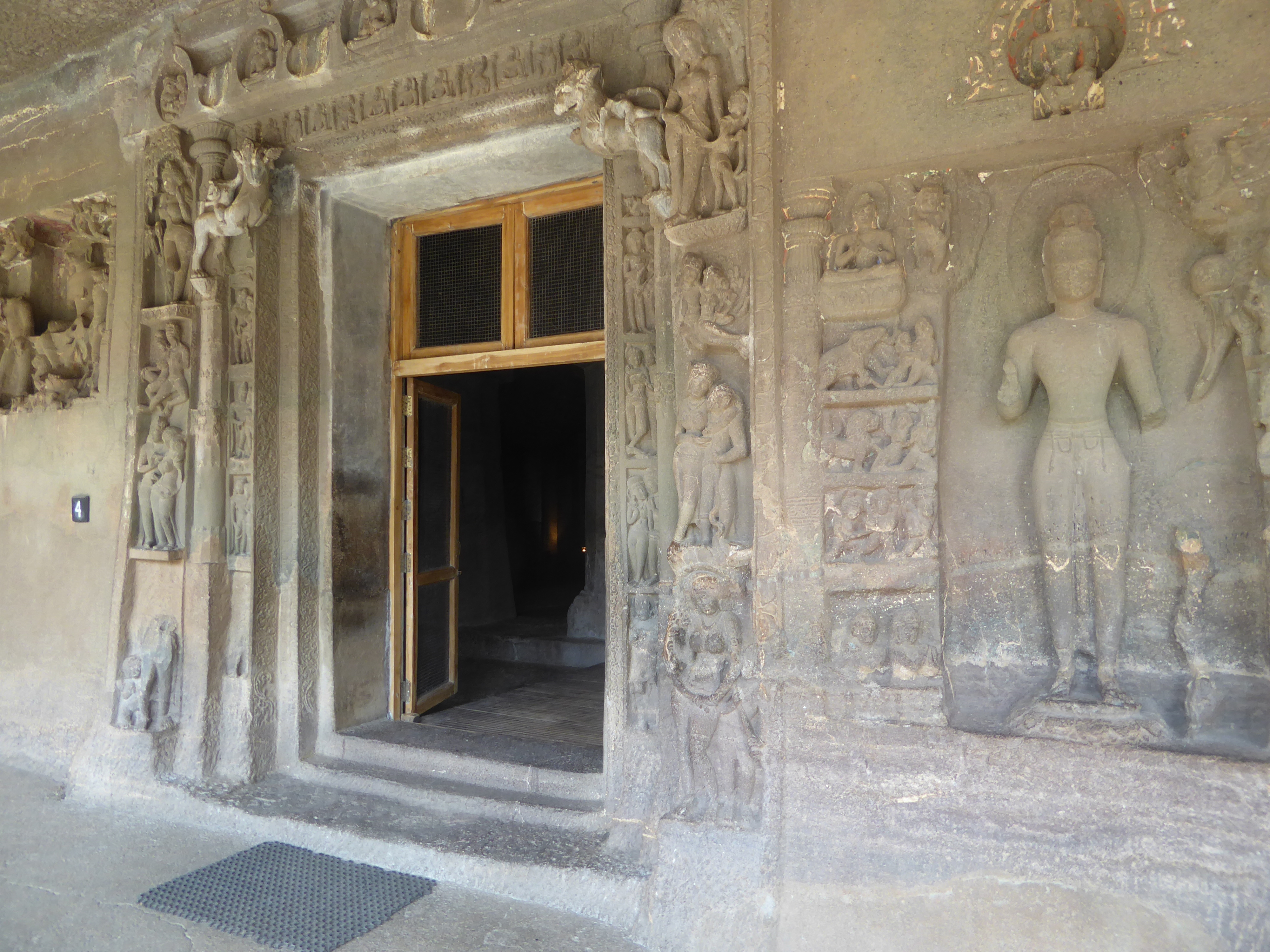 The large figure on the right is an intrusion, added in the troubled times after the death of Harisena. The figure is Avalokiteshvara, and t