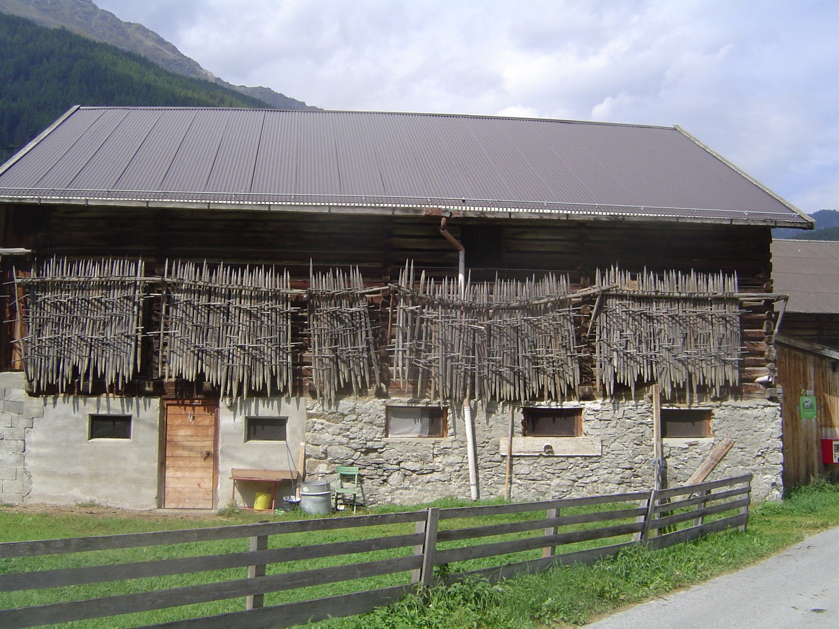 Hay is stacked around stakes that are themselves neatly arranged for safekeeping.