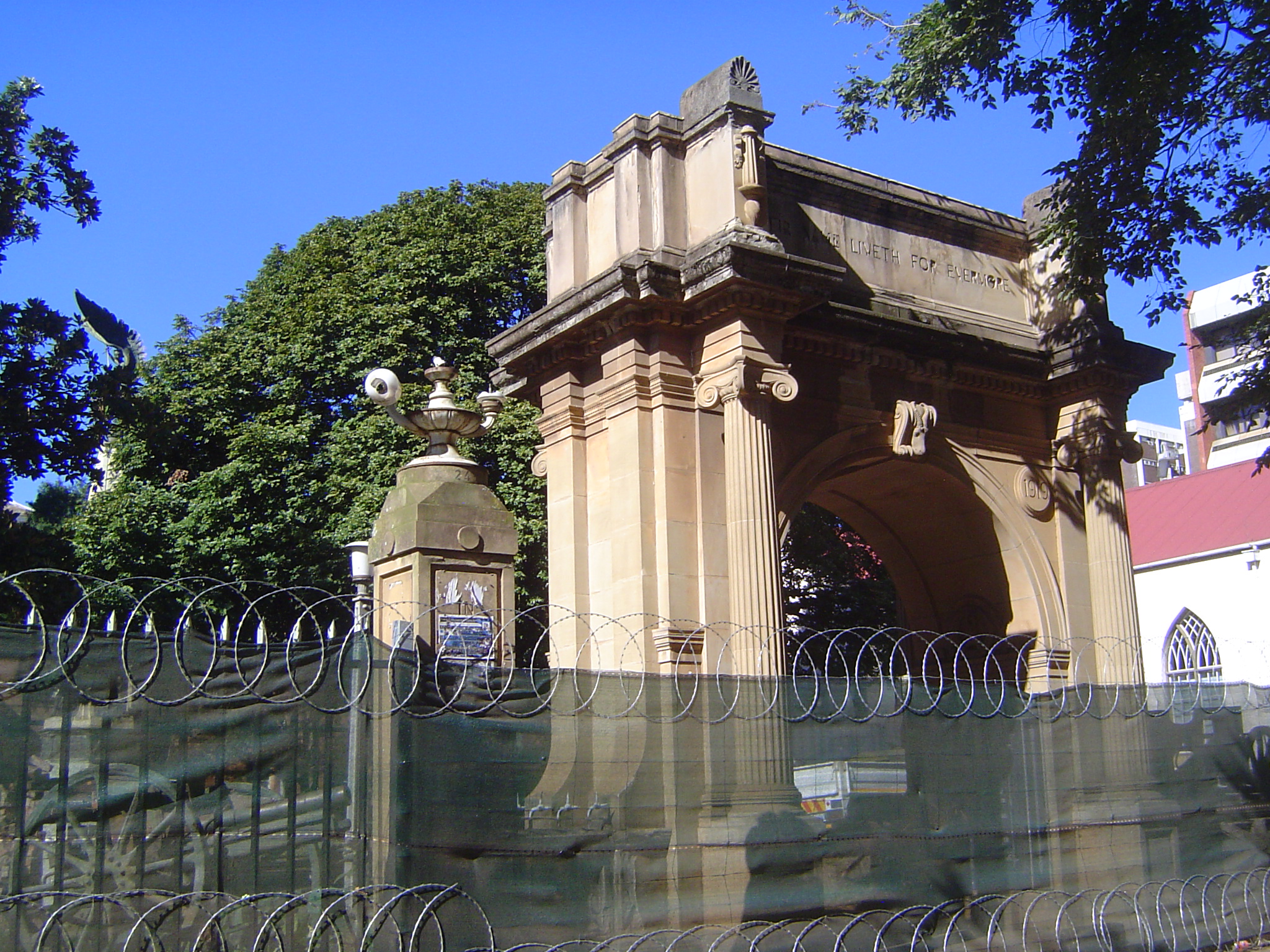 A war memorial arch from 1922 is drastically fenced off from a construction site.