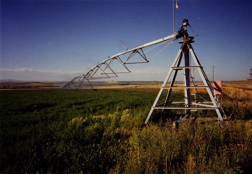 Back in the states, this time in Idaho, a center pivot swings across a field of potatoes. A long way from second homes. Note the tiny discha