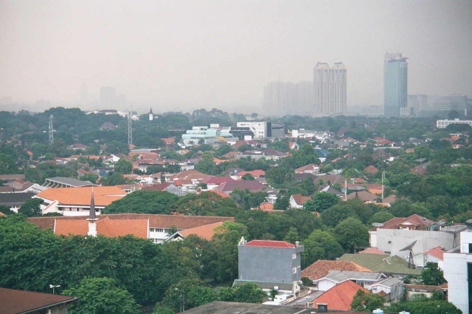 From the same roof, the view southeasterly is over the old but pricey district of Menteng, beyond which lie more towers of the new Jakarta.