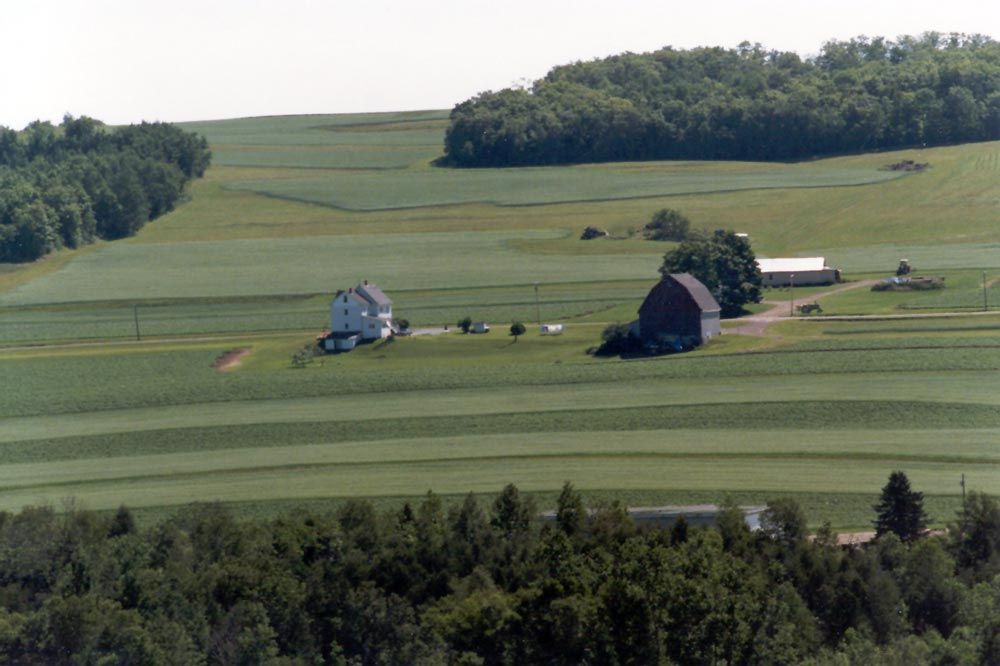 A typical farmstead: forest, the two crops, a barn. Passing through the middle of the picture is Highway 161, the main route between the St.