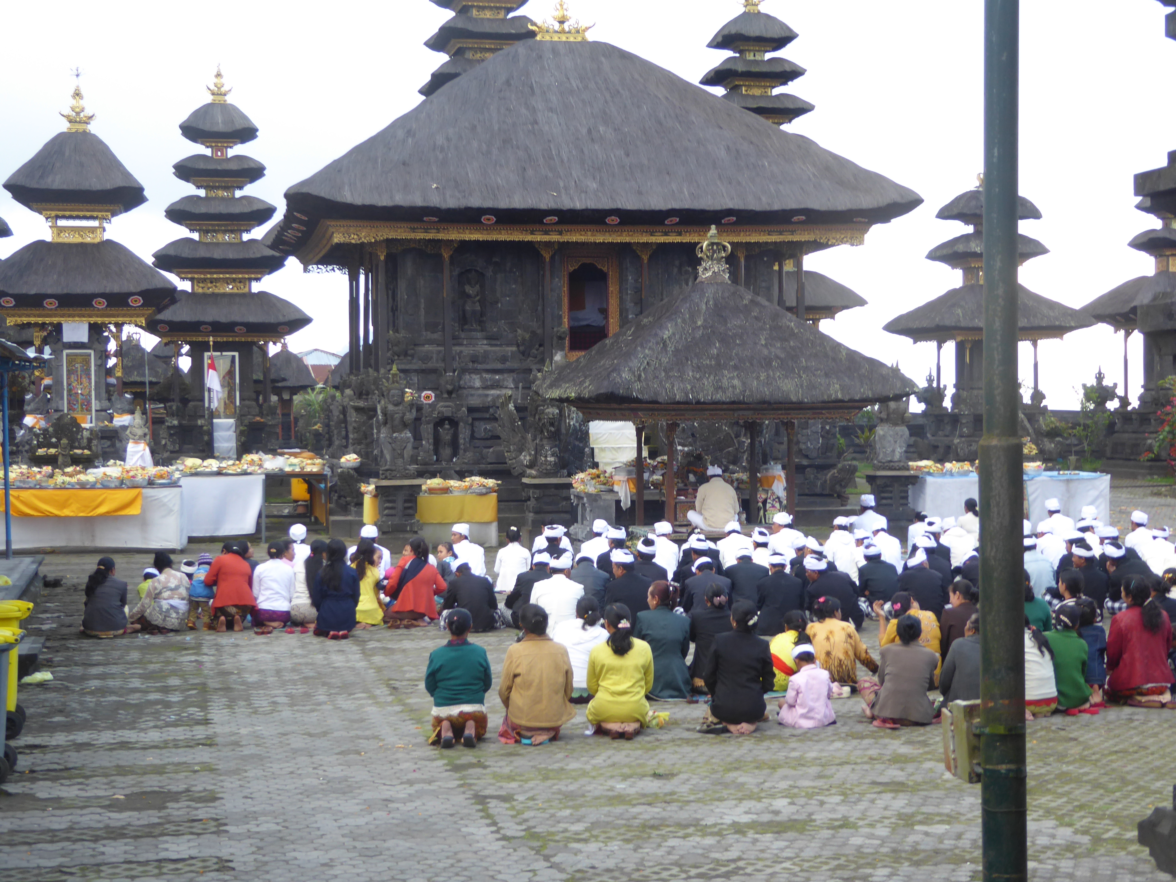 Members of one association kneel before a bale or pavilion. The pyramidal roof is in itself a tipoff that this is a temple: secular building