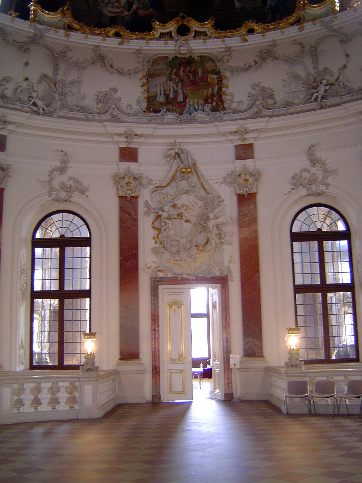 The platform atop the staircase leads into rooms on either side. Keep an eye on the plasterwork over the door.