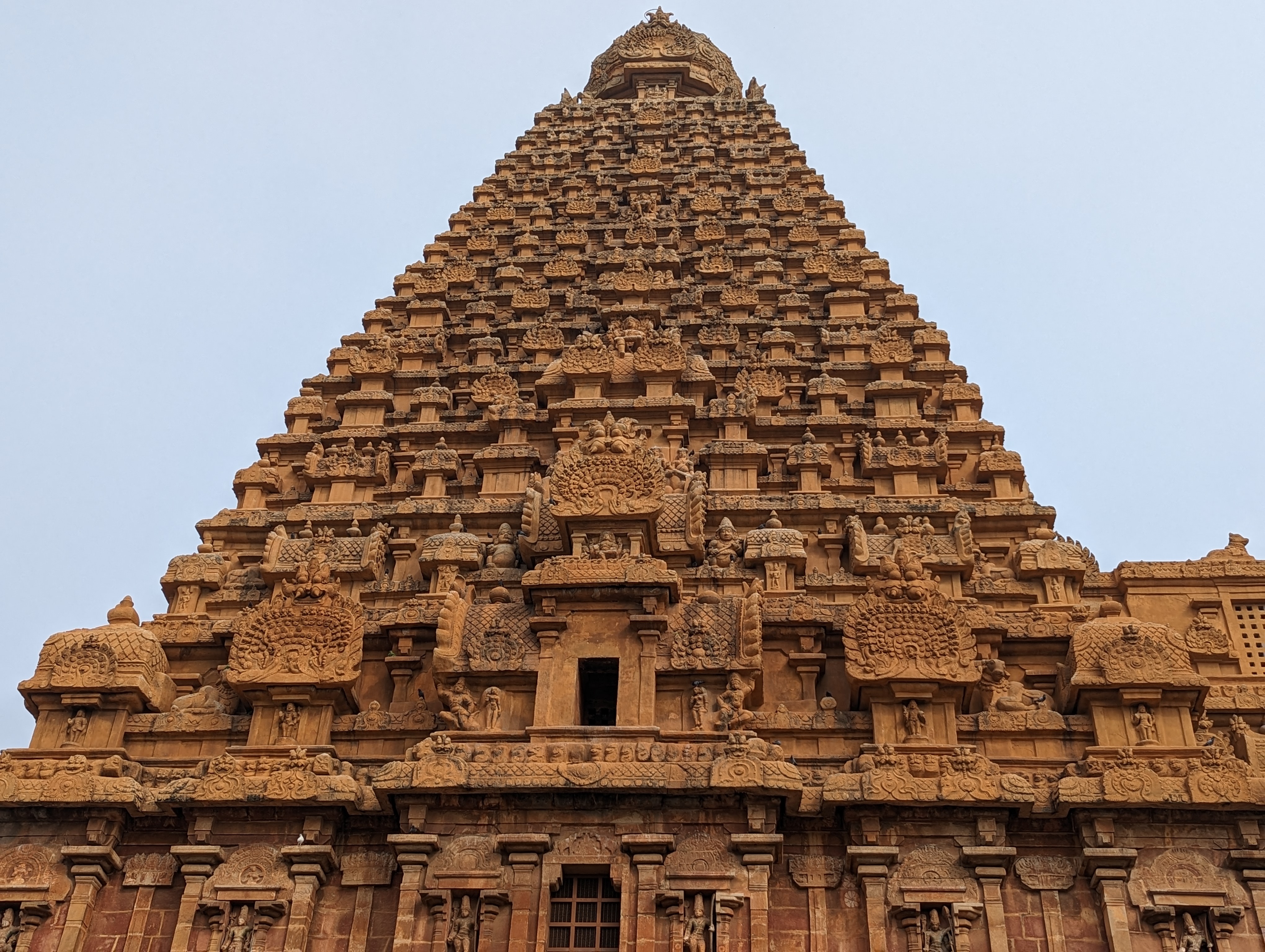 There are a dozen square tiers under a conical cap.  The regularity of the ornamentation reminds me a supermarket display of soft drinks.  T