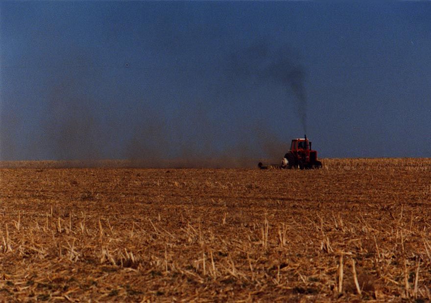 Tractor at work, dust on the move.