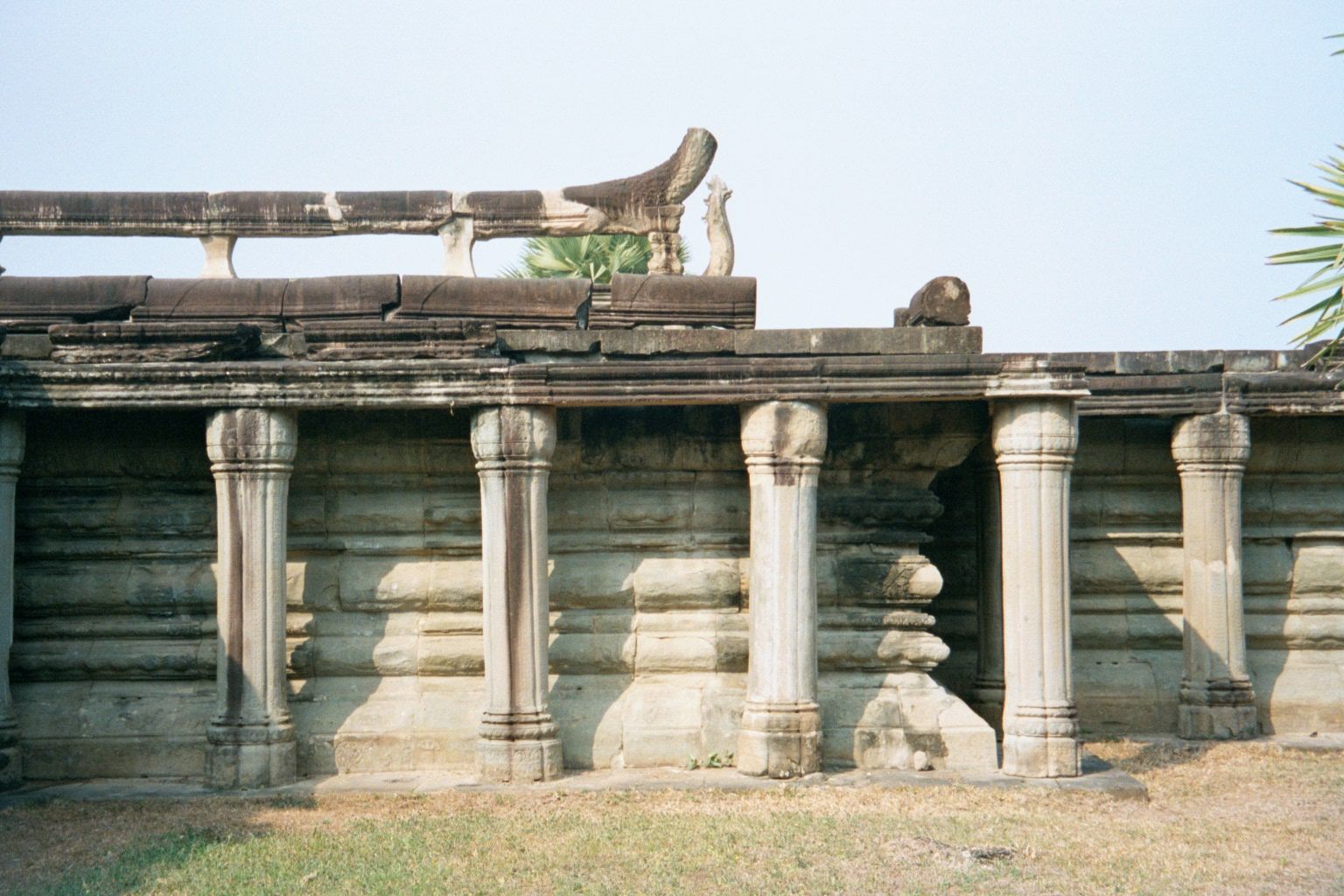Another detail of the causeway, this time showing not only the round columns but the naga or serpent balustrade, with its vertically flaring