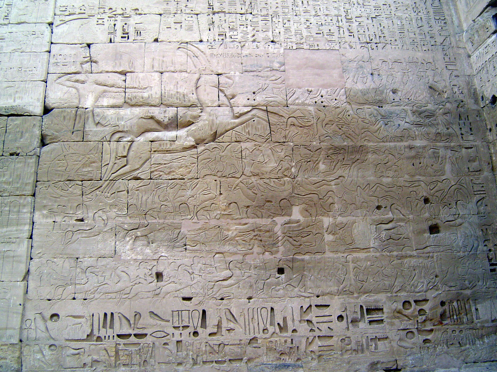 Here, on the back of the first pylon, the king in his chariot drives through battlefield chaos.