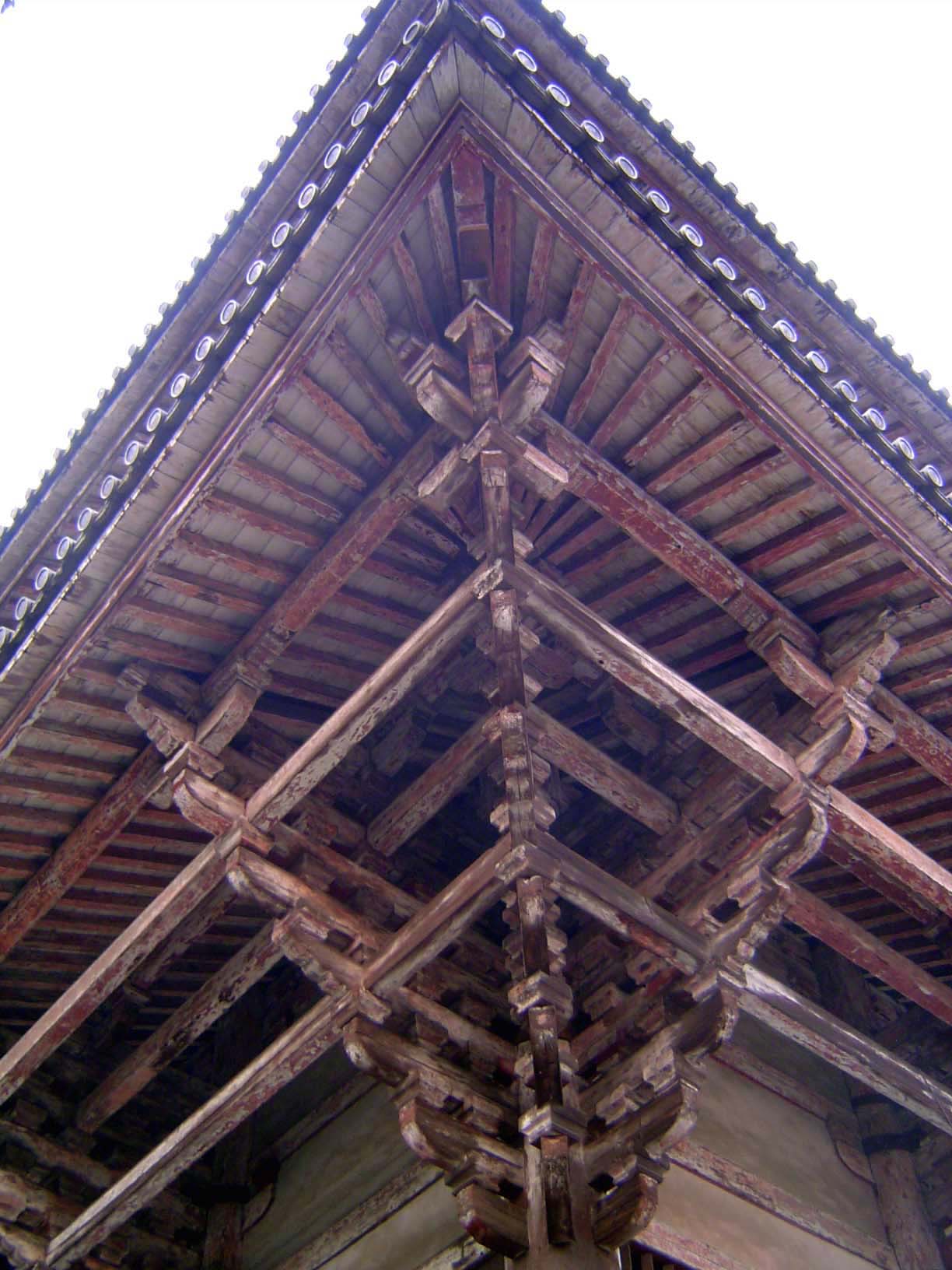 These compounded brackets are extensions of the beams and purlins. They pass through the corner pillar and support the lower eave, which in