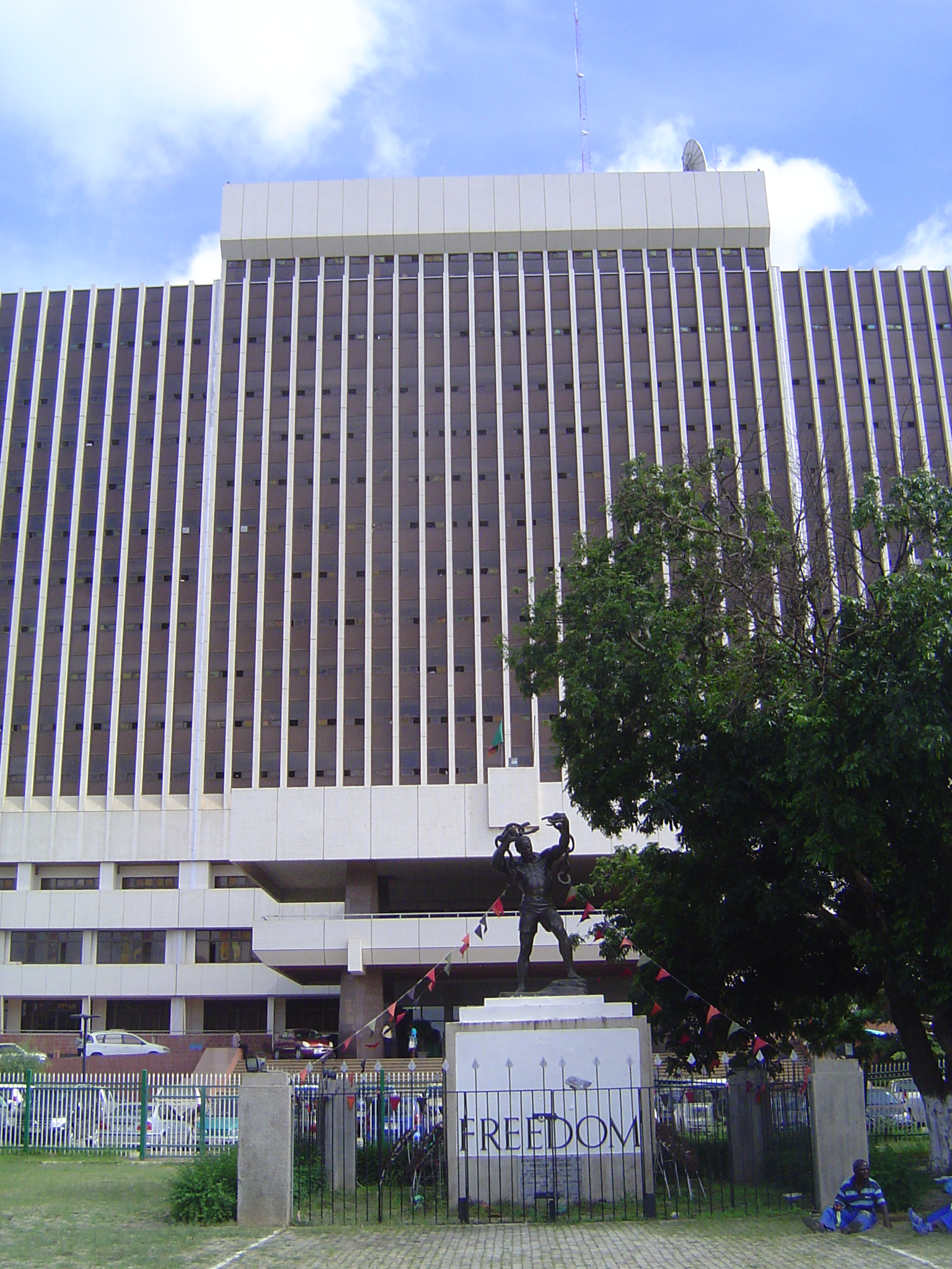 Facing the street is the Government Complex. In front of it is a monument unveiled in 1974 on the tenth anniversary of independence.