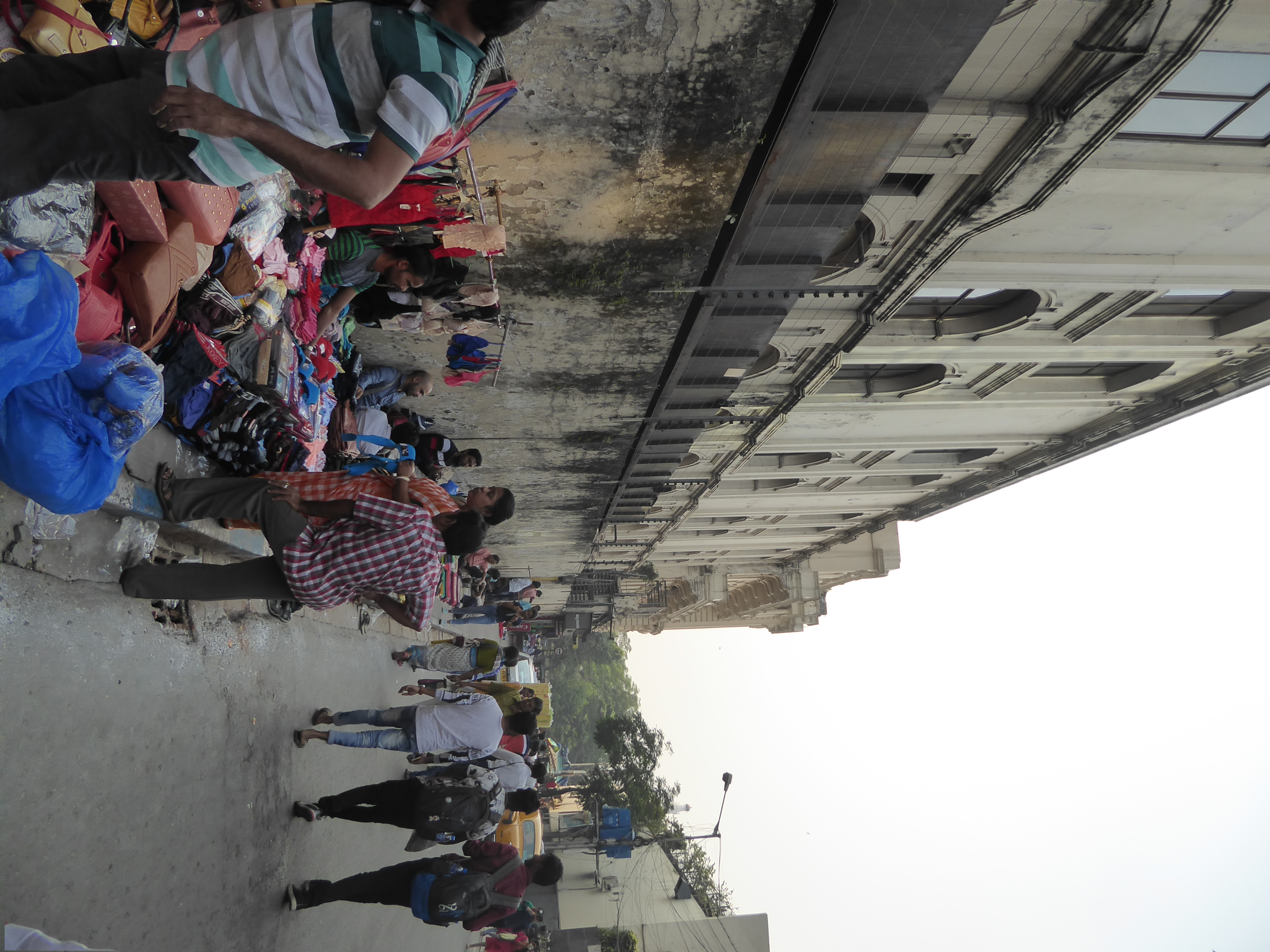 Chowringhee, and the greenery of the maidan, is up ahead. We'se stepped off the thoroughfare and are on the north side of the Oberoi, its wa