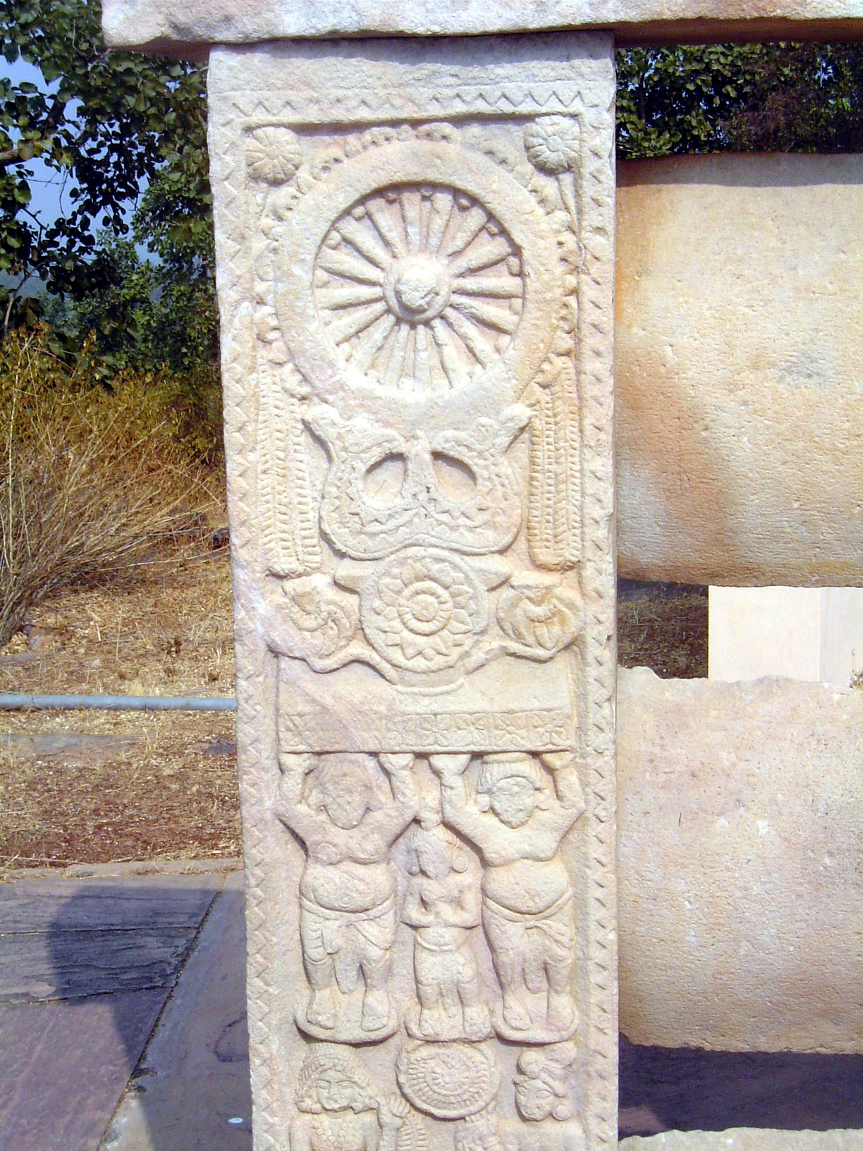 There are other images, too, including this Wheel of the Law, supported by a Triratna.