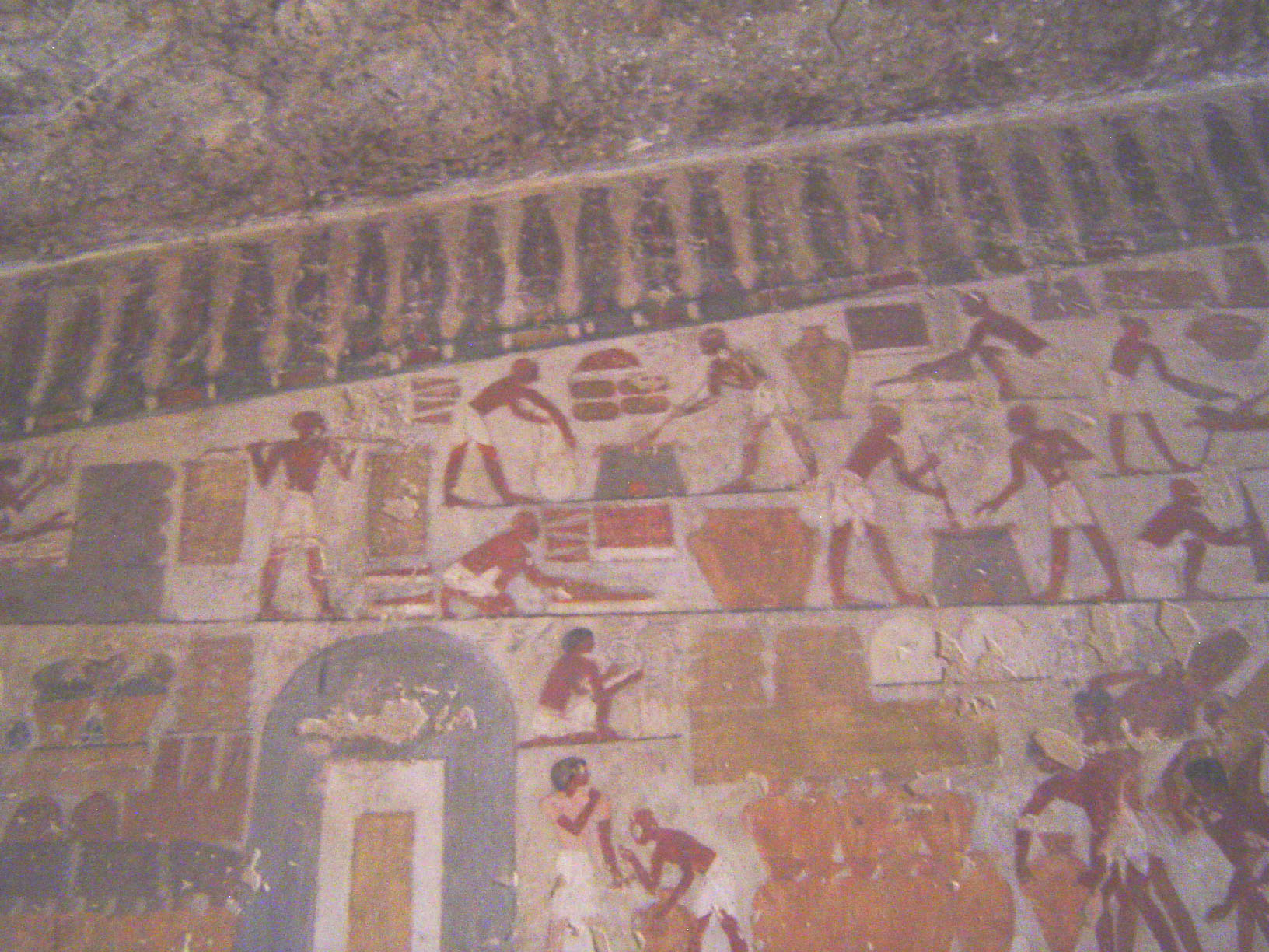 Higher on the same wall, there's a portrayal of the storerooms of the Temple of Amun at Karnak. At the lower left, goods are piled before th