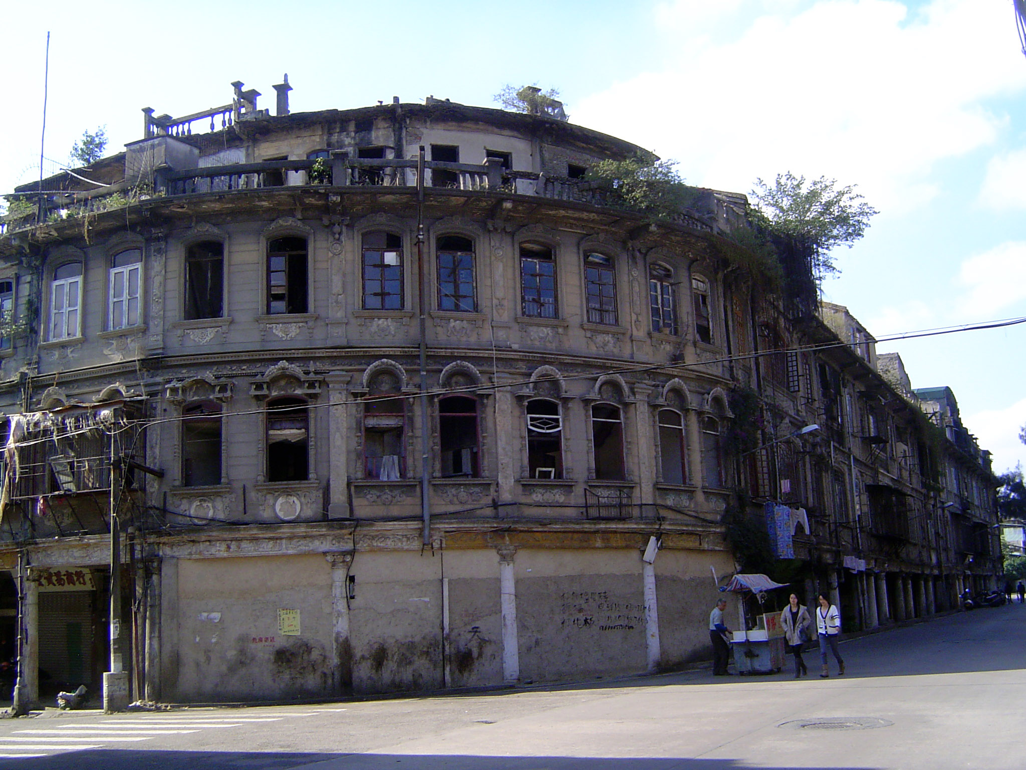 I said that this neighborhood was decrepit; here's an example, with storefronts blocked up, windows missing, and rooftop gardens growing of