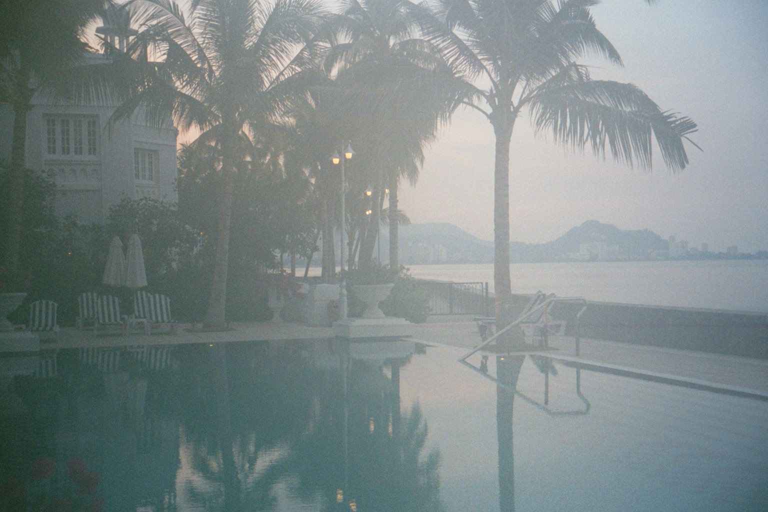 The hotel pool fronts the seawall, where a line of highrise apartments can be detected along the distant skyline.